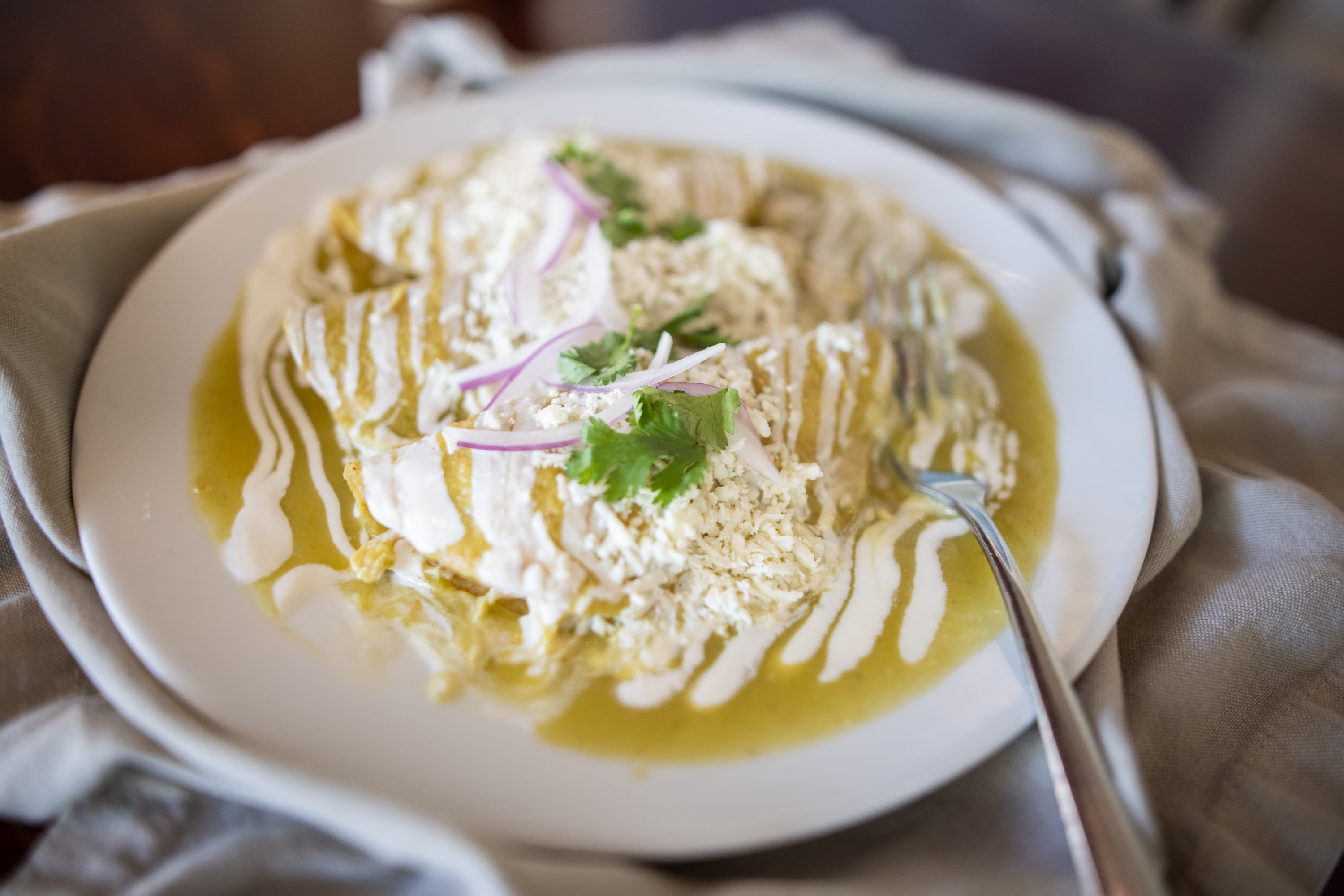 Enchiladas Verdes with Creamy Sauce and Fresh Garnishes