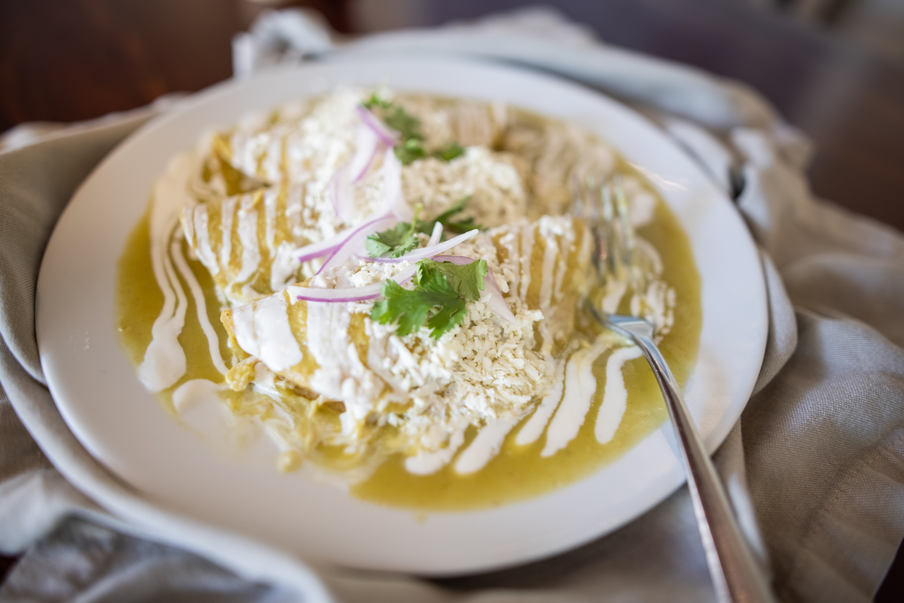 Enchiladas Verdes with Creamy Sauce and Fresh Garnishes