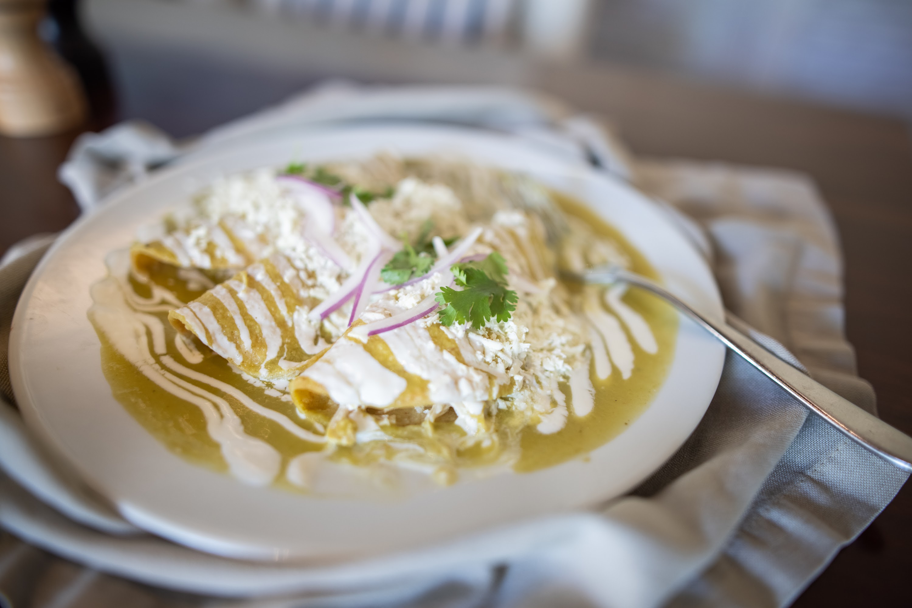 Green Enchiladas with Creamy Sauce and Fresh Garnishes