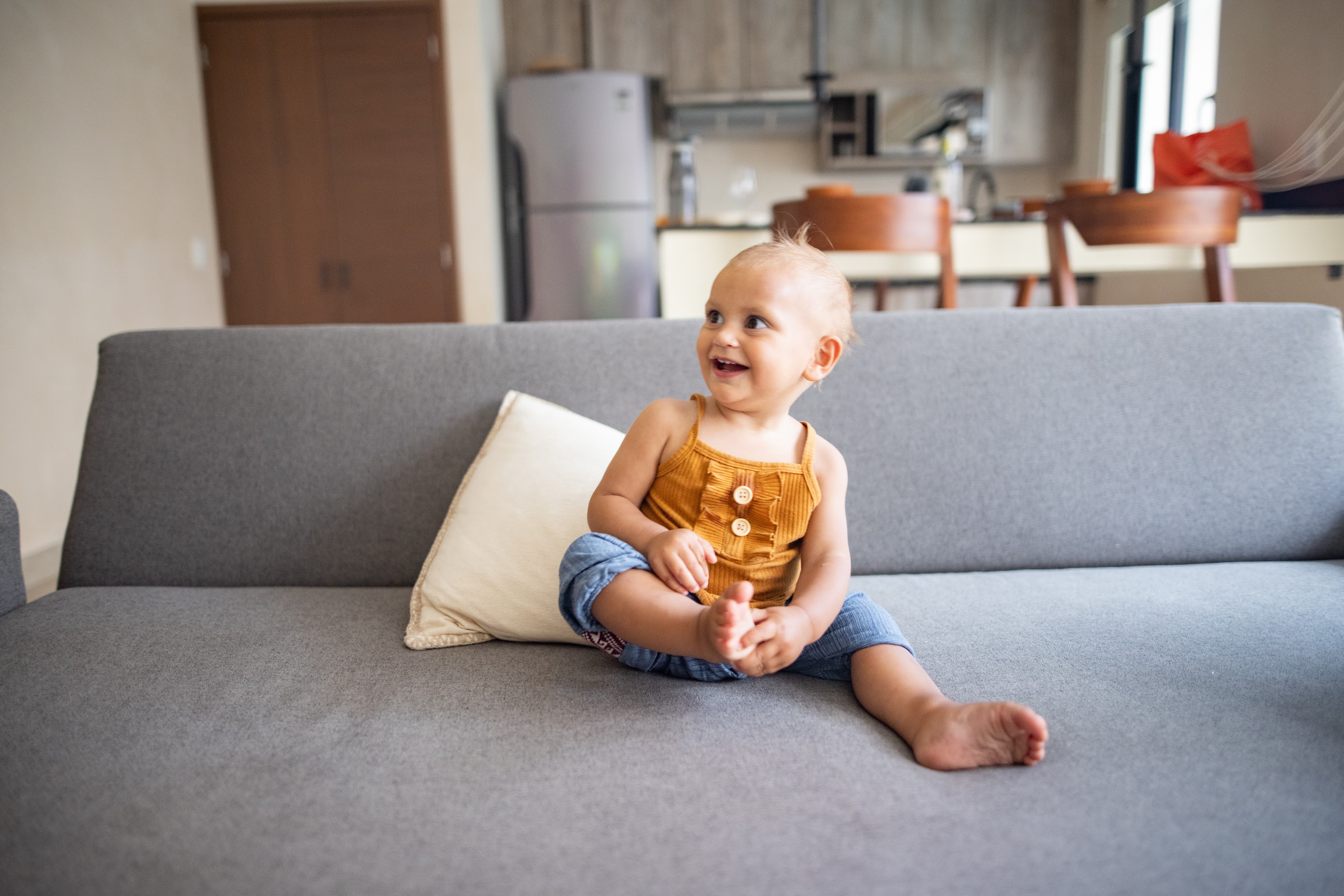 Happy Baby Sitting on Gray Couch