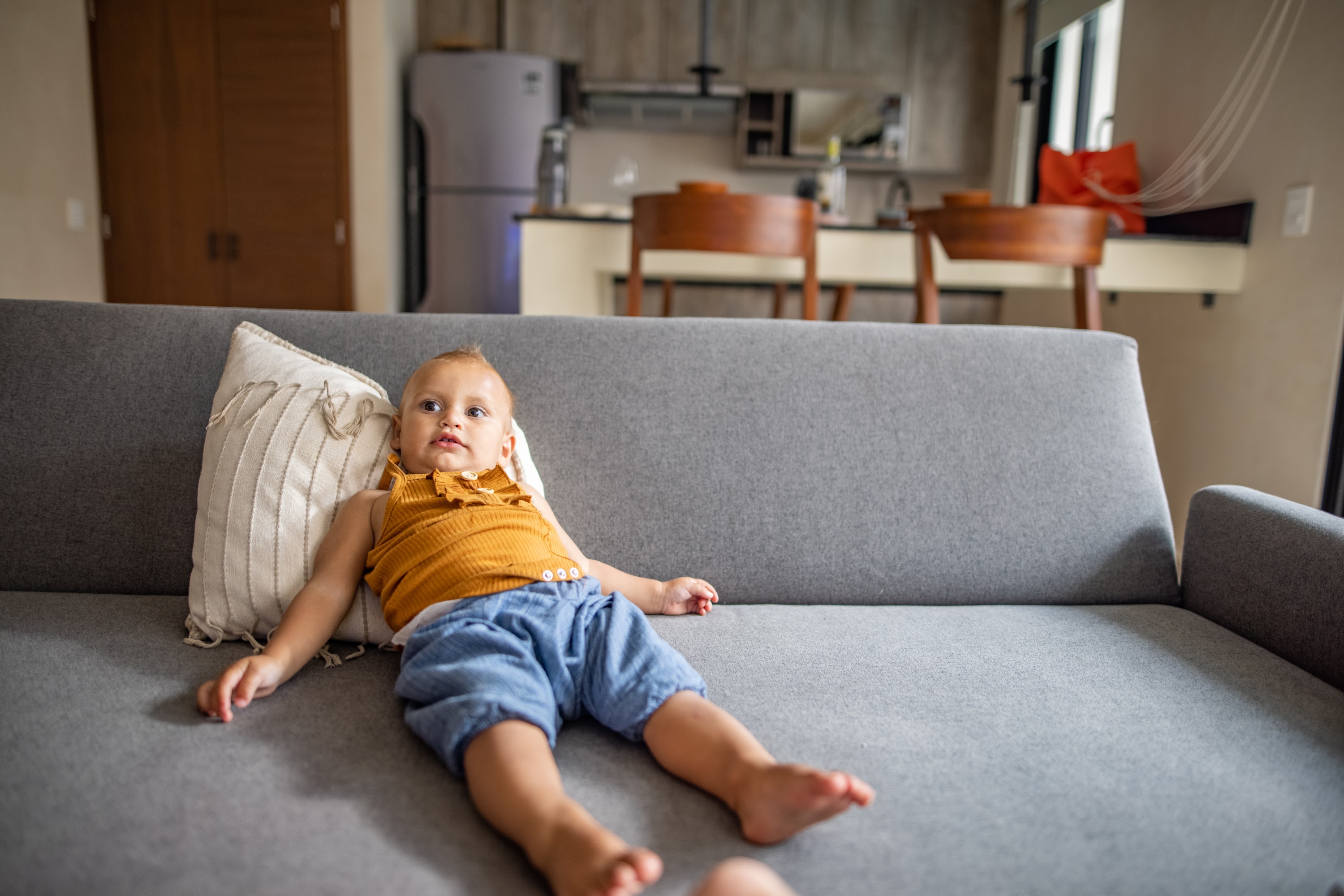 Baby Relaxing on Gray Couch in Modern Living Room