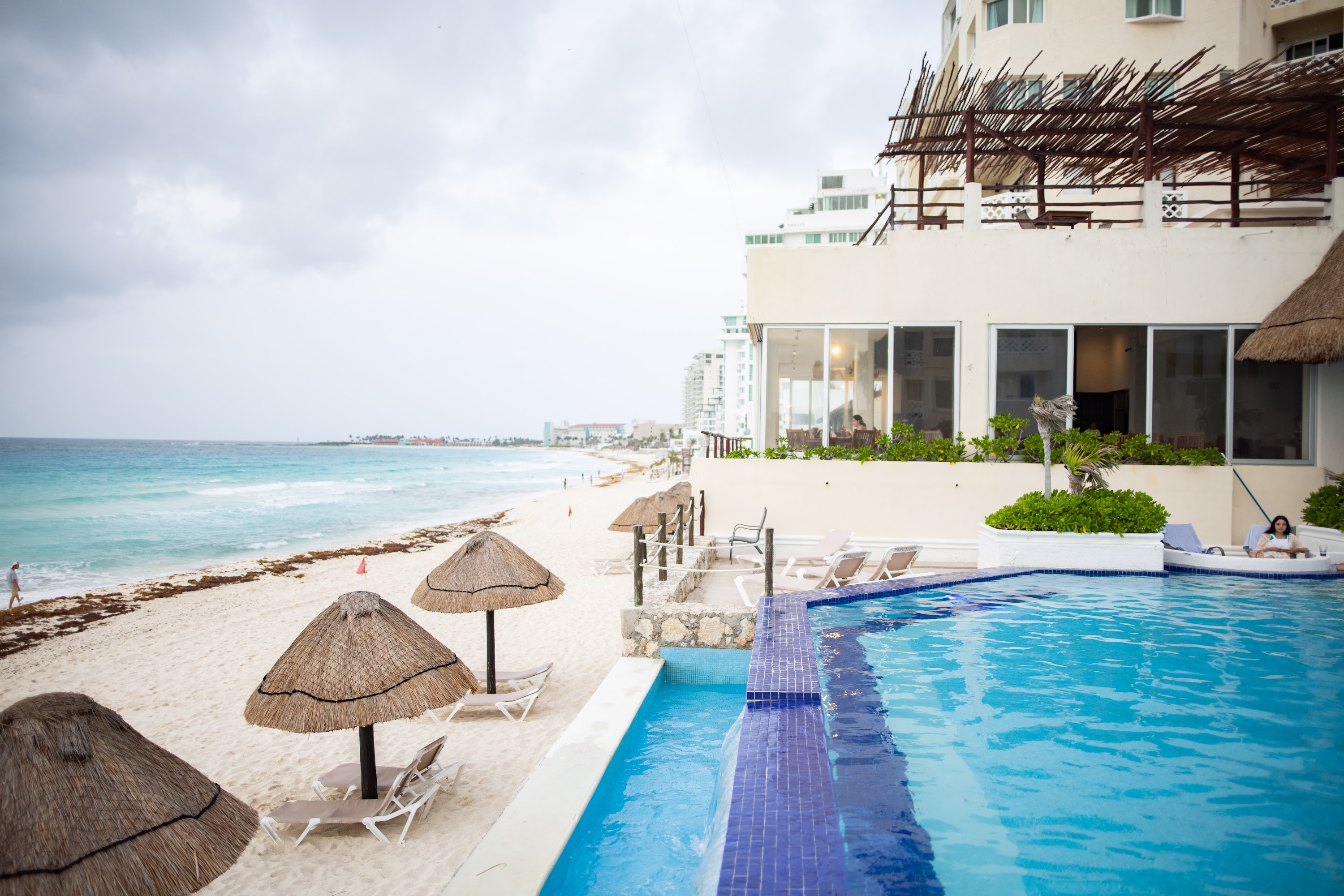 Beachfront Resort Pool with Thatched Umbrellas and Ocean View