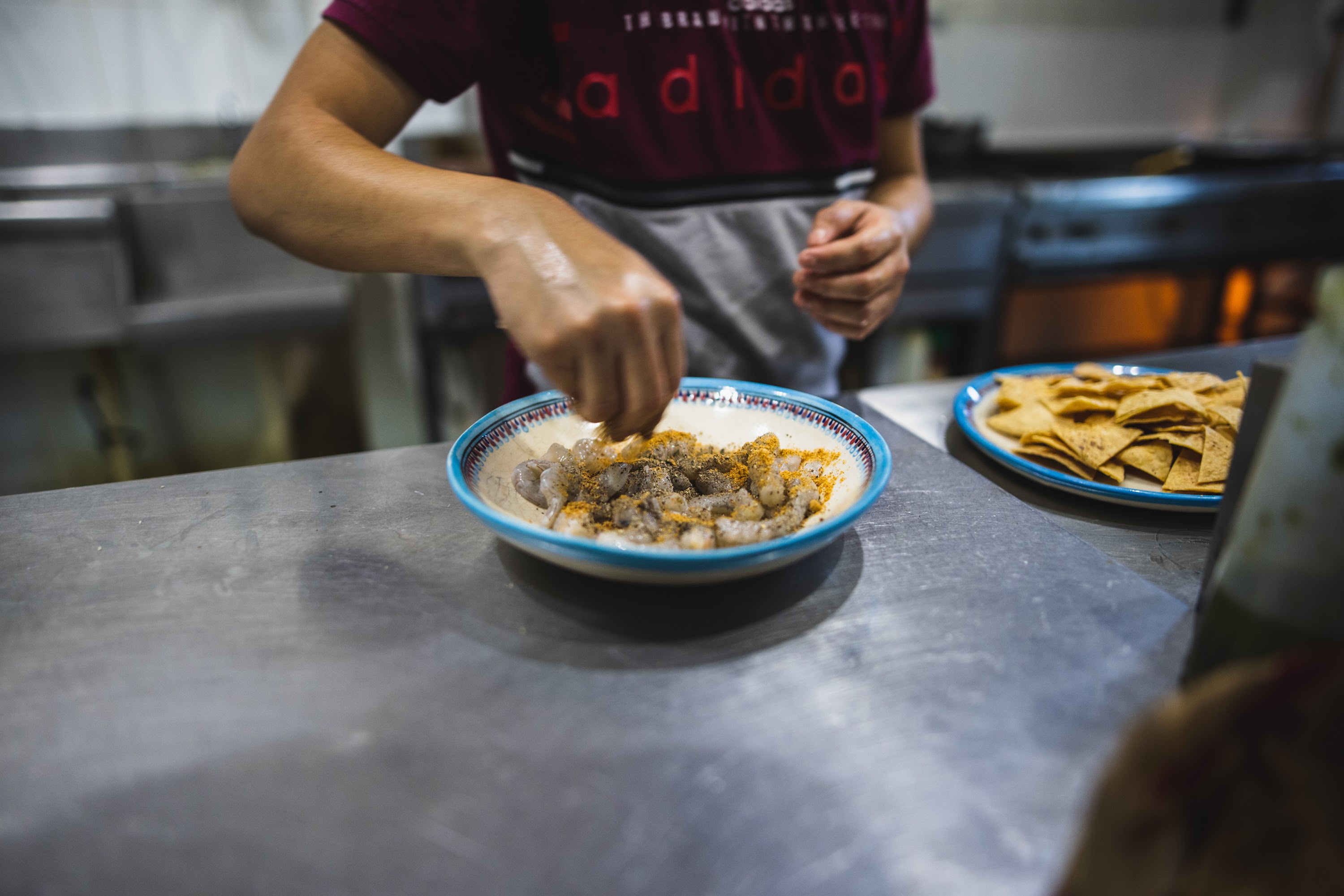 Chef Preparing Shrimp with Spices in a Kitchen