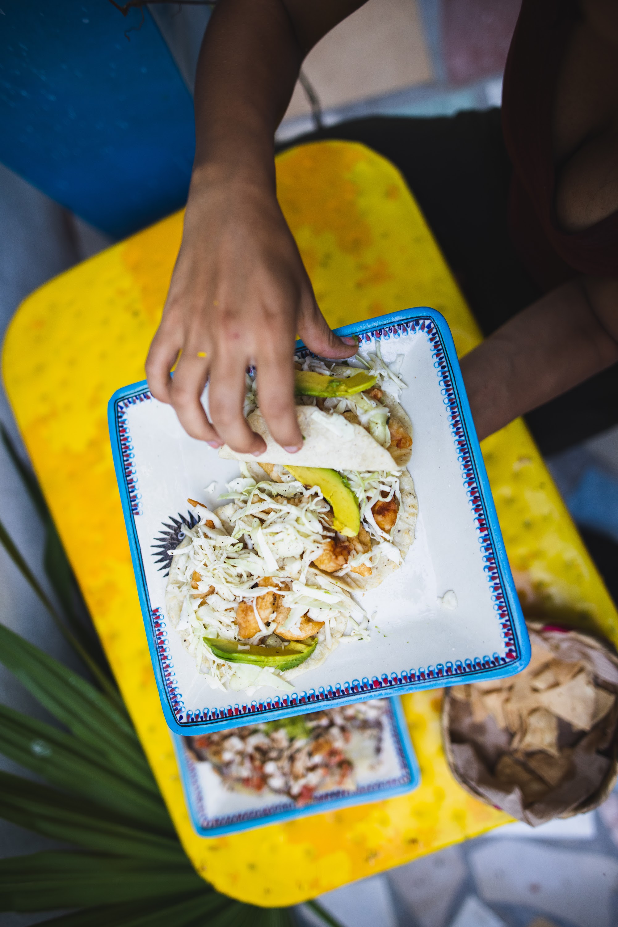 Hand Placing Tacos on a Decorative Plate