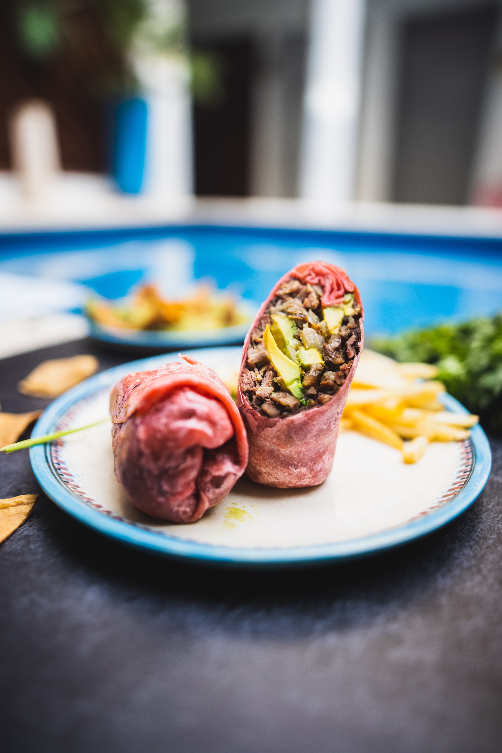 Close-up of a Cut Wrap with Avocado and Meat on a Plate
