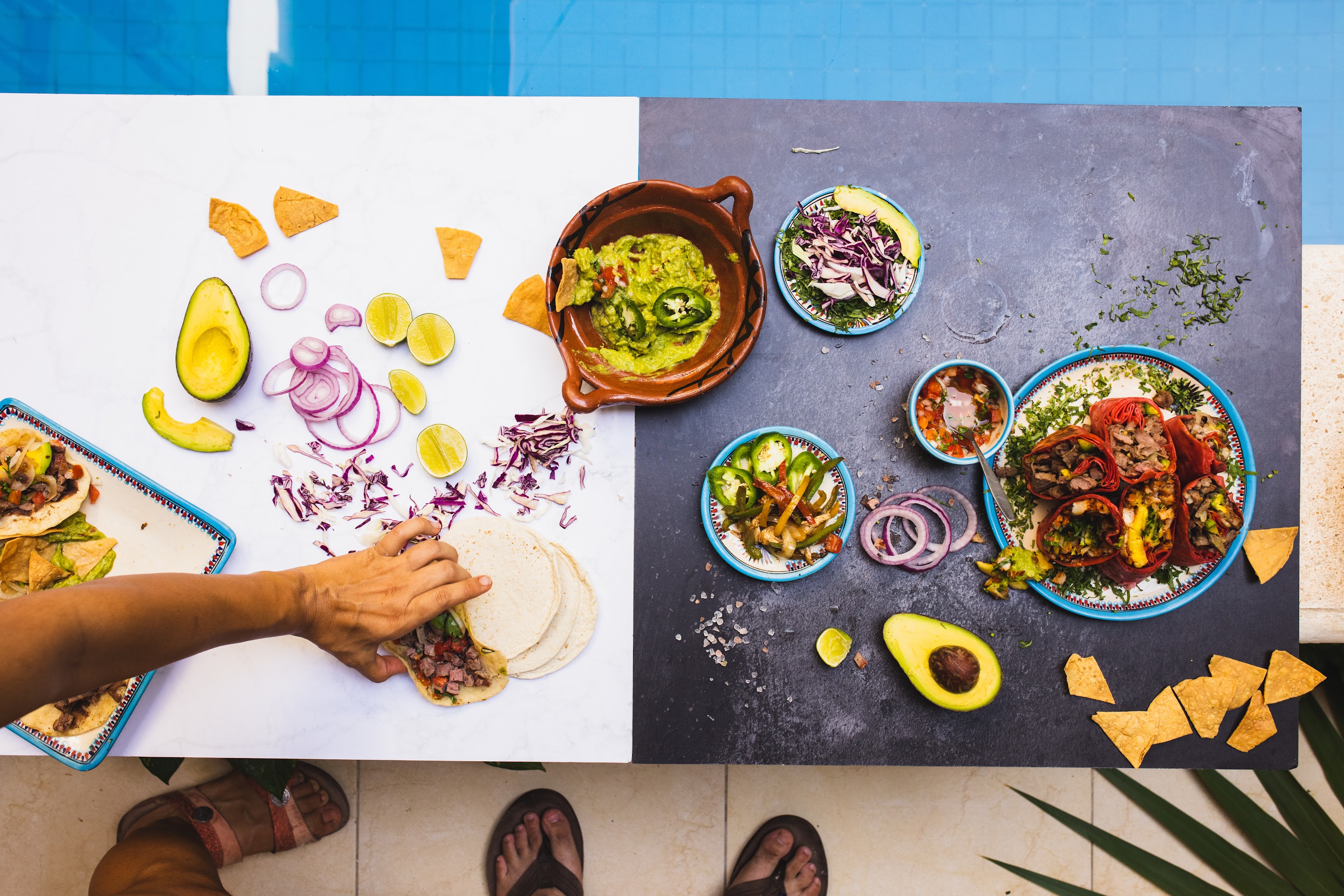 Top-down view of taco preparation by a poolside table