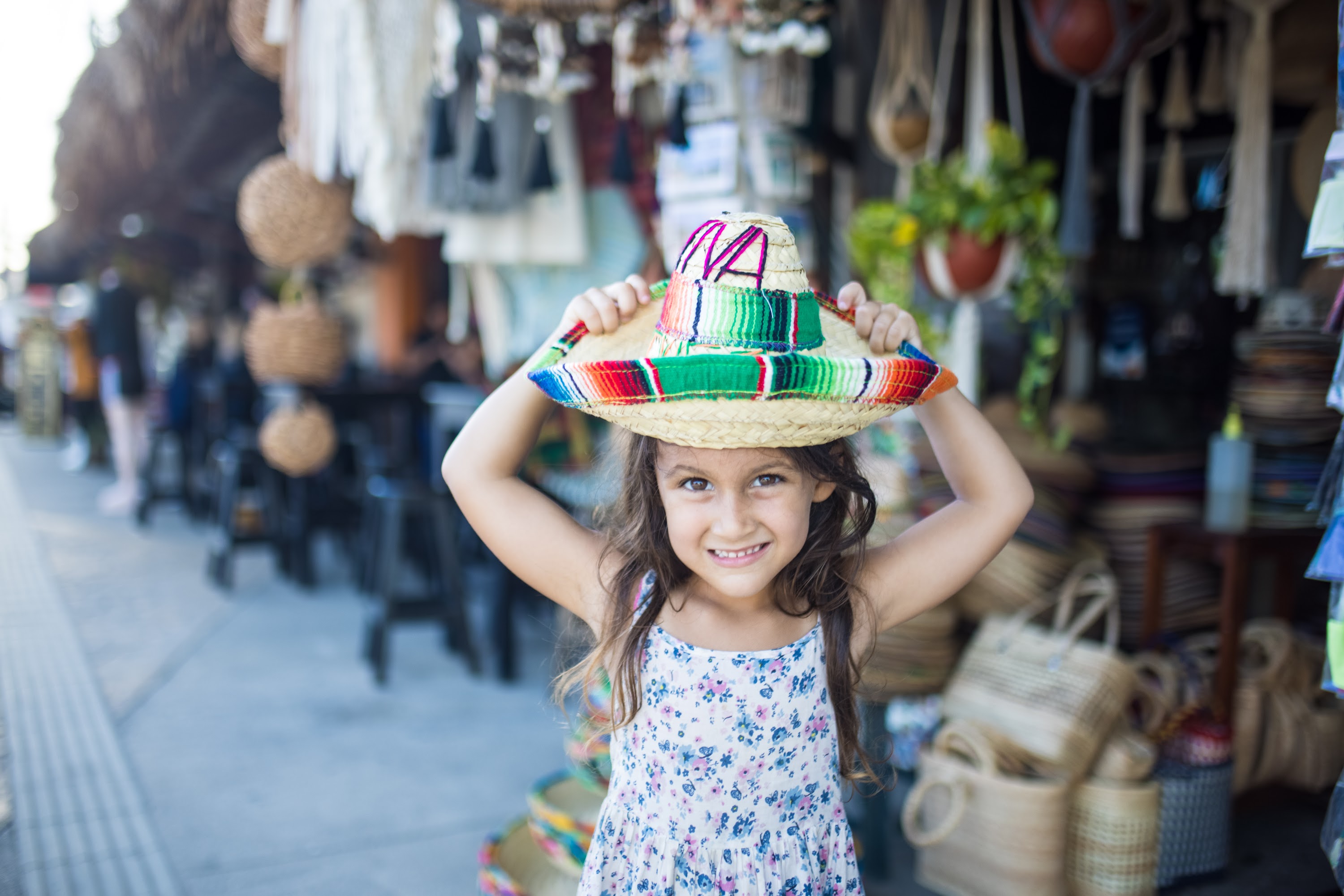 Happy Girl Holding Colorful Sombrero at Outdoor Market