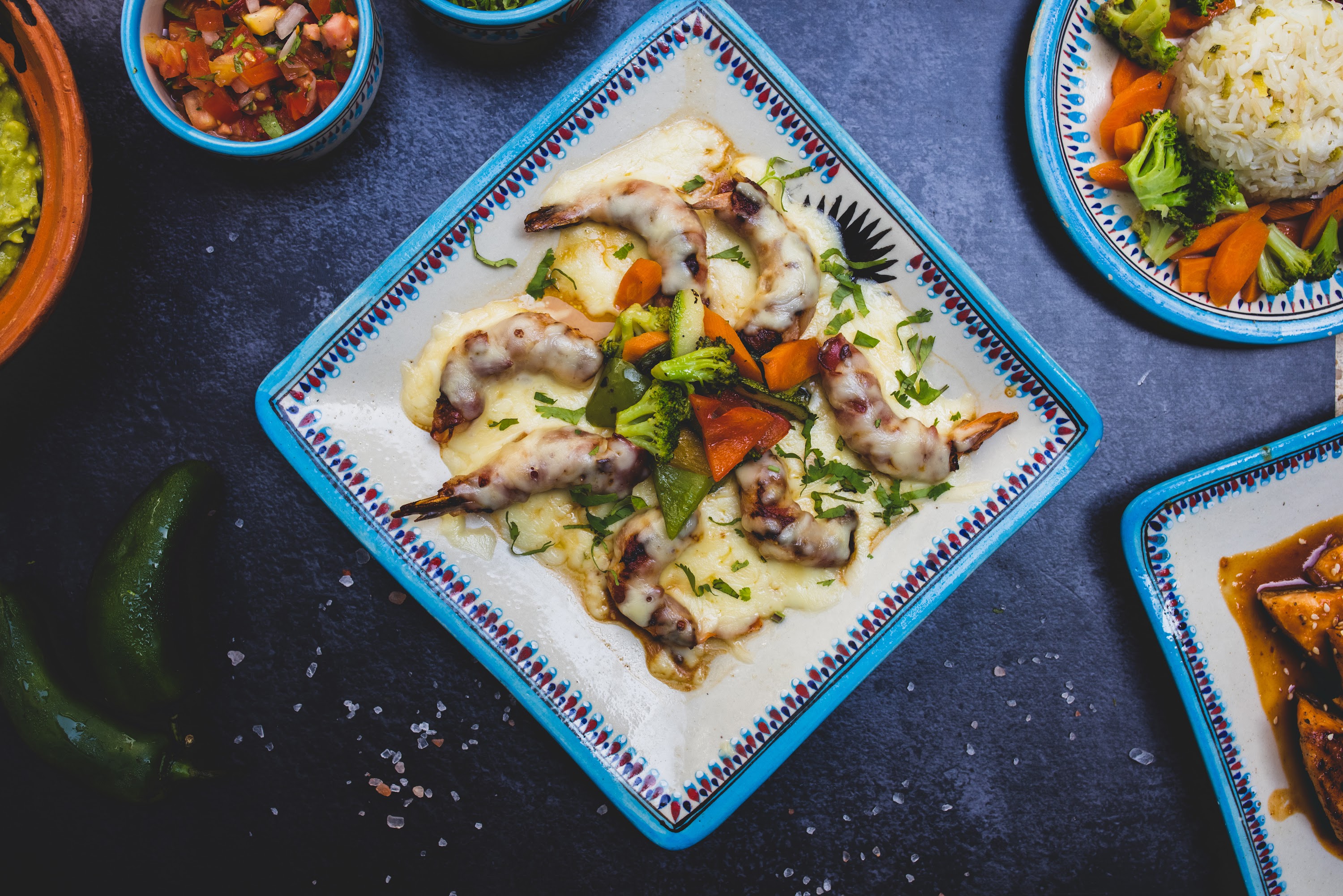 Mexican-style shrimp dish with melted cheese and vegetables