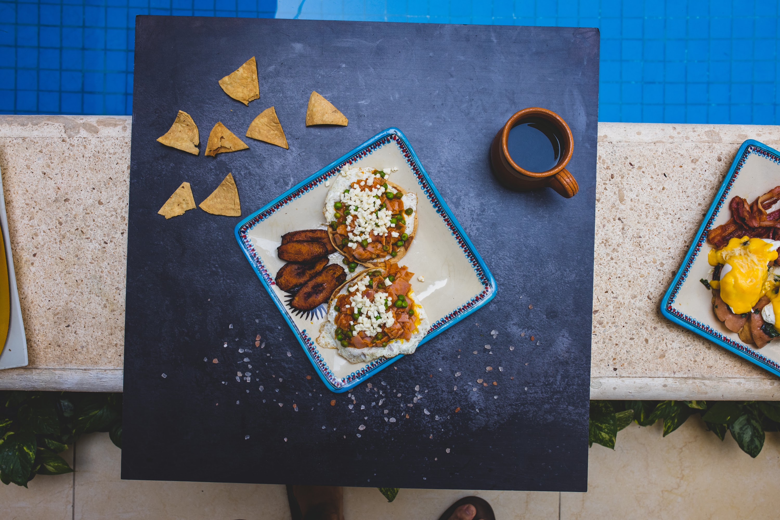 Top-down view of Mexican-inspired breakfast plates by a poolside