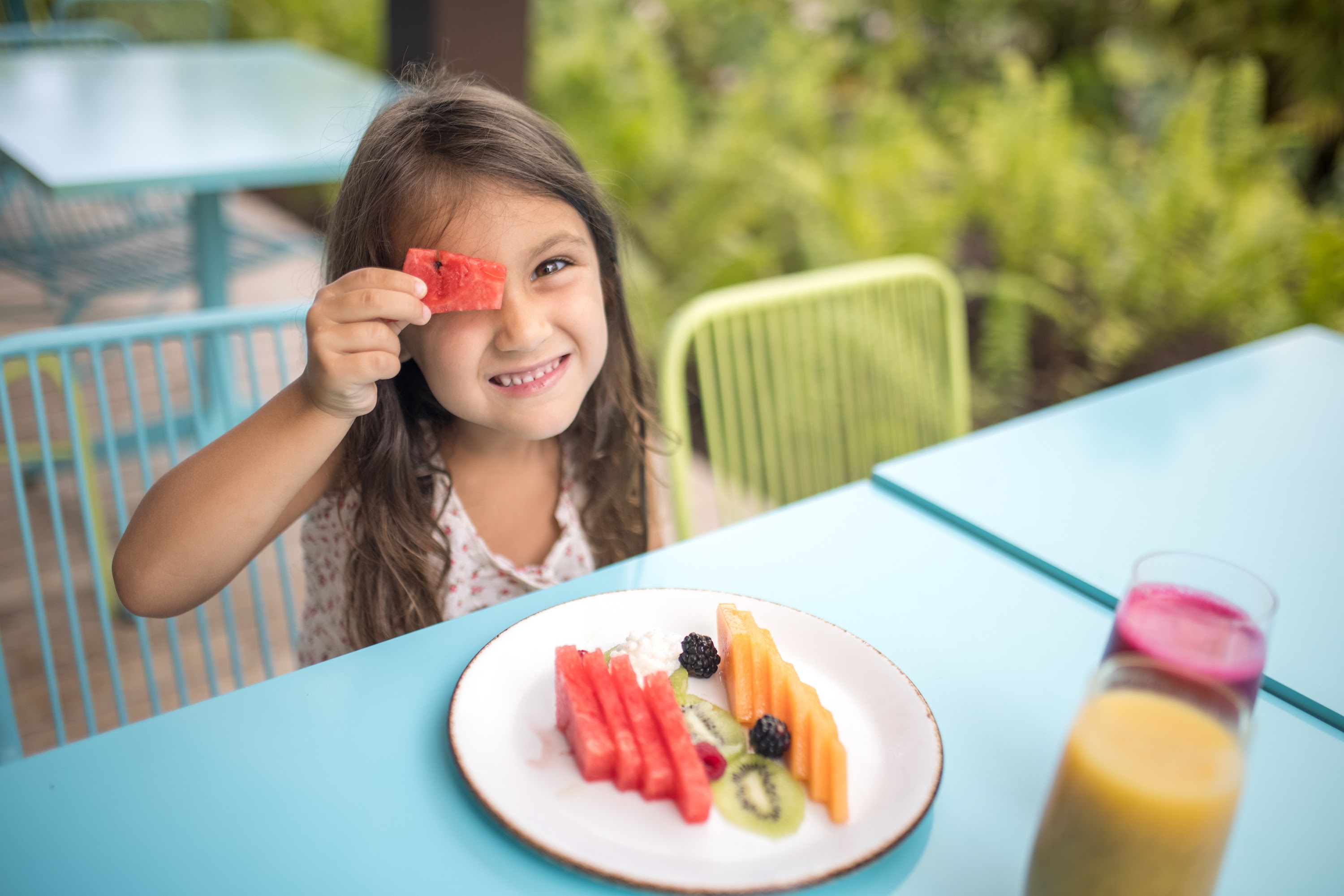 Happy Girl Enjoying Fruit Plate Outdoors