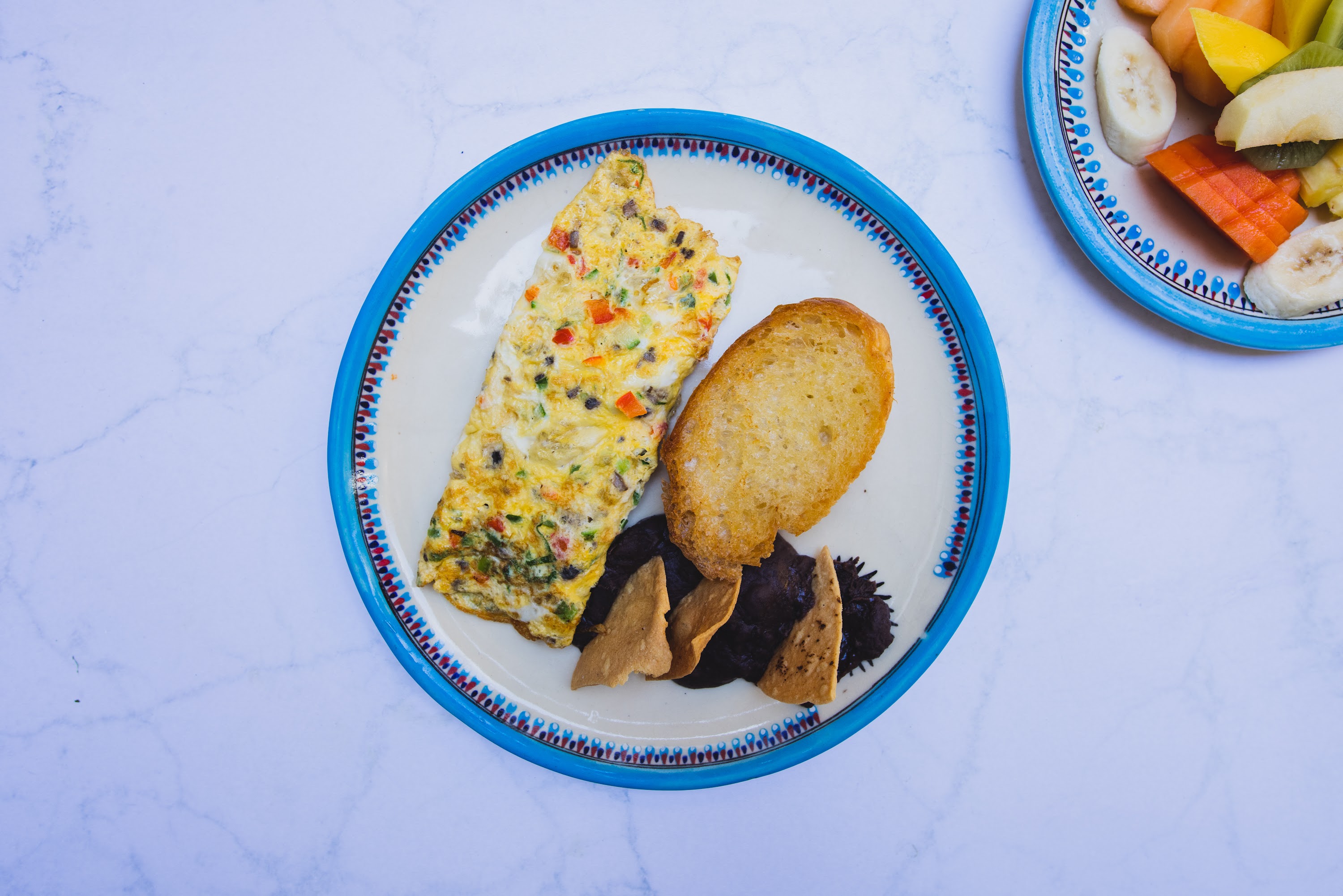 Colorful Omelette with Toast and Chips on Blue-Rimmed Plate