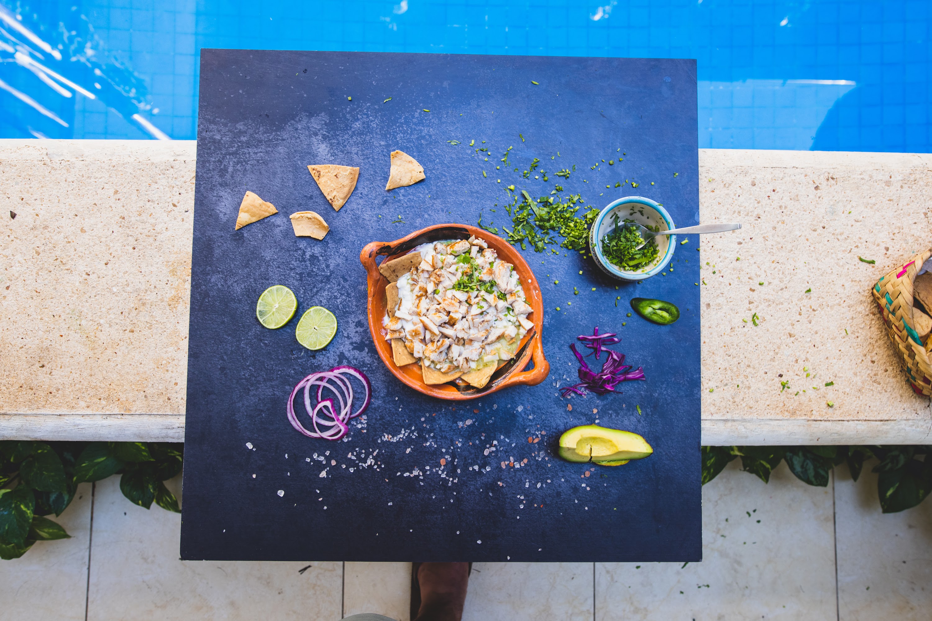 Top-down food photography of seafood nachos by a poolside