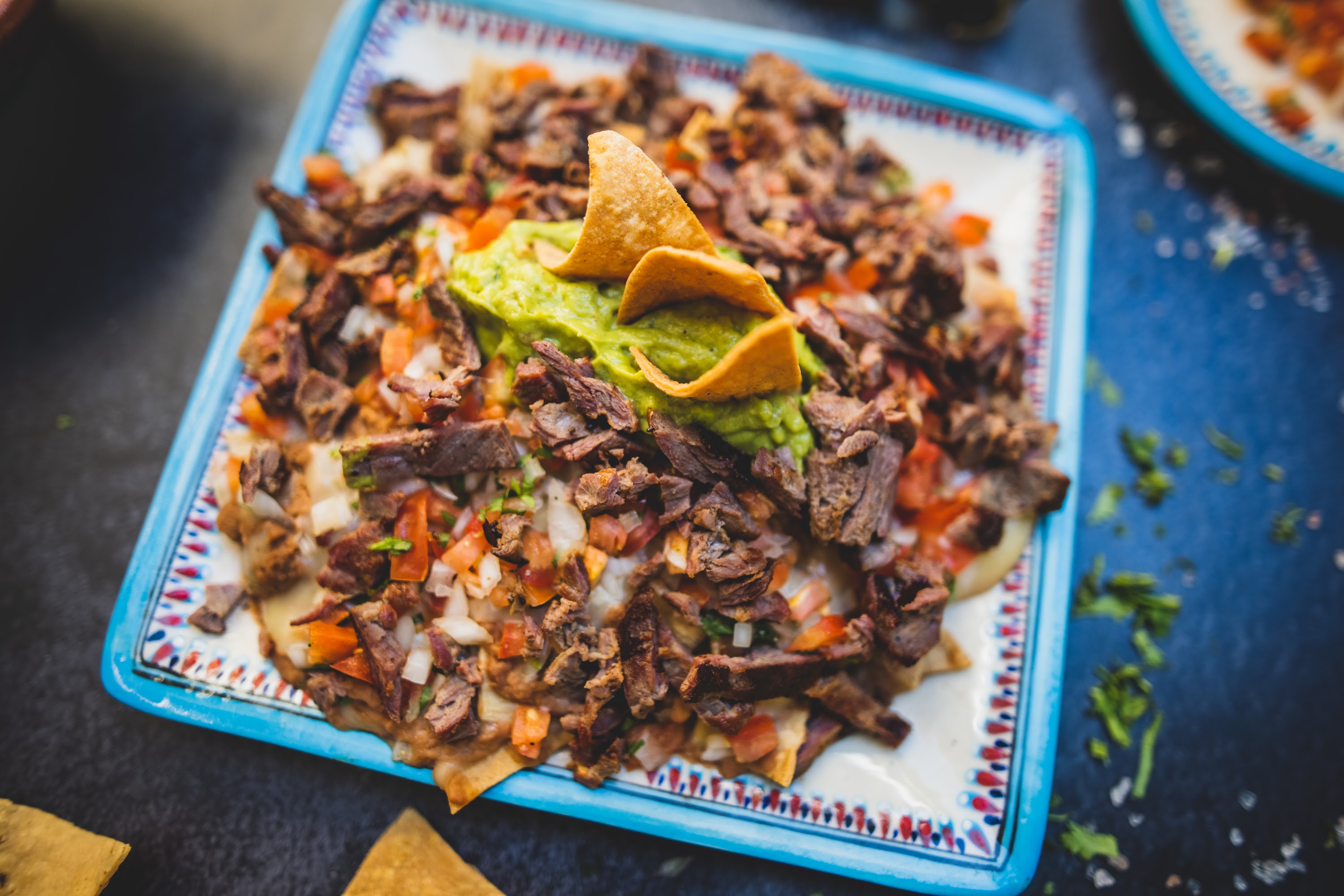 Mexican-style nachos with shredded beef, guacamole, and tortilla chips