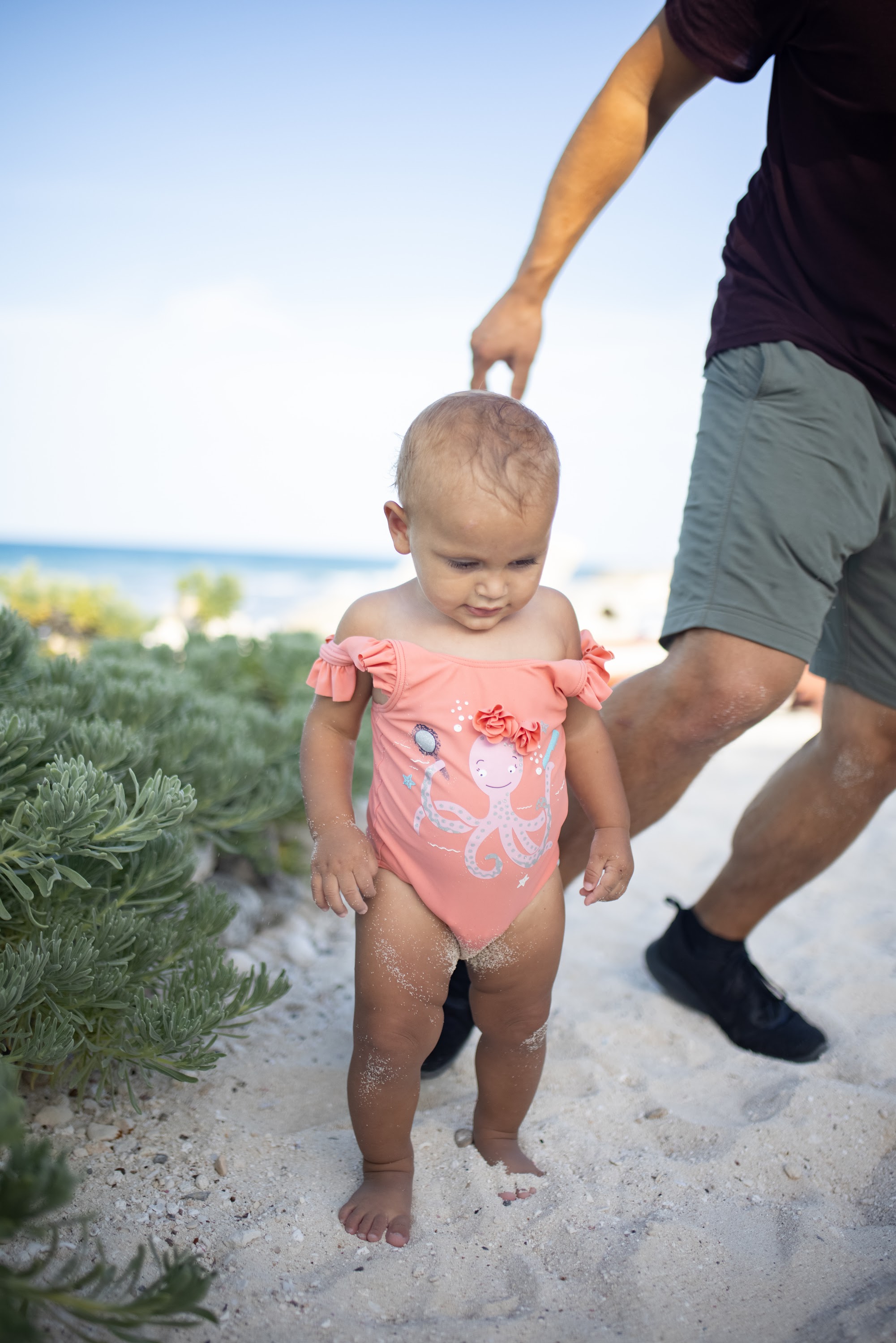 Baby in Octopus Swimwear Walking on Beach