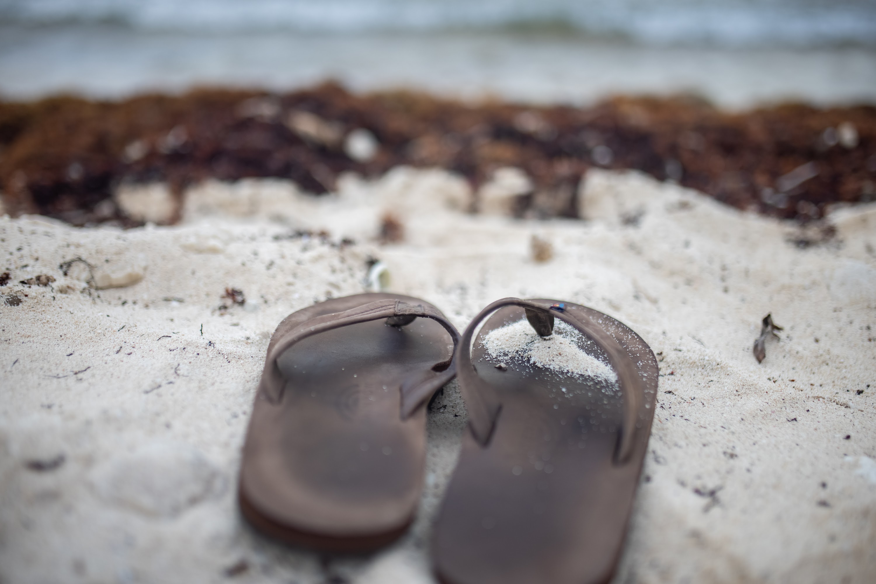 Brown Flip-Flops on Sandy Beach
