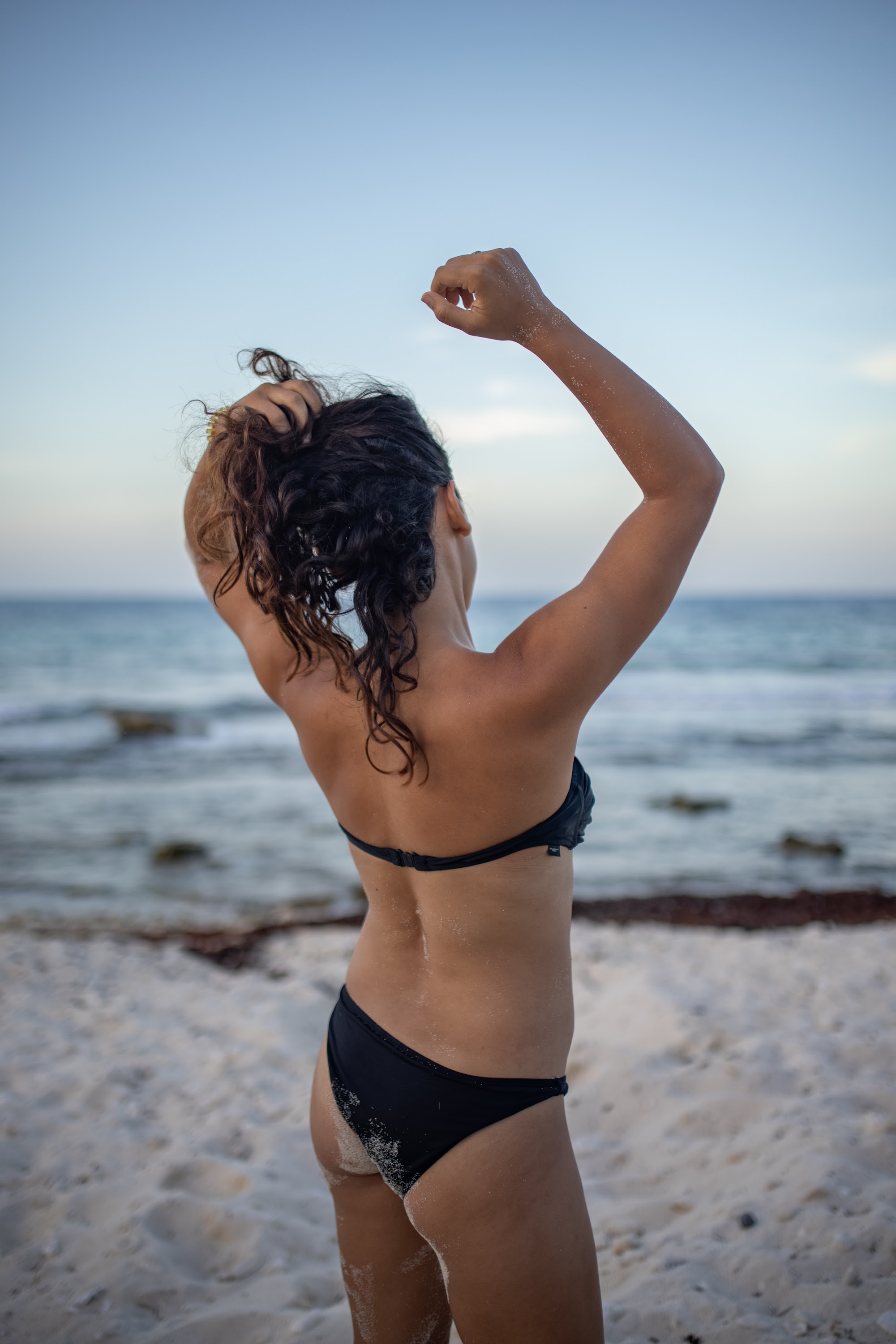 Woman in Black Bikini on Beach at Sunset