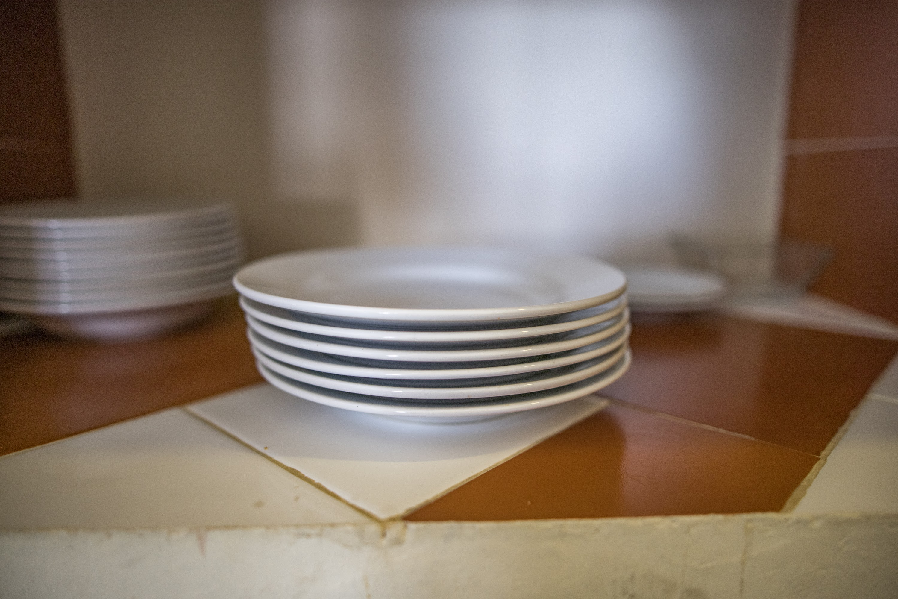 Stack of White Plates on Tiled Kitchen Counter