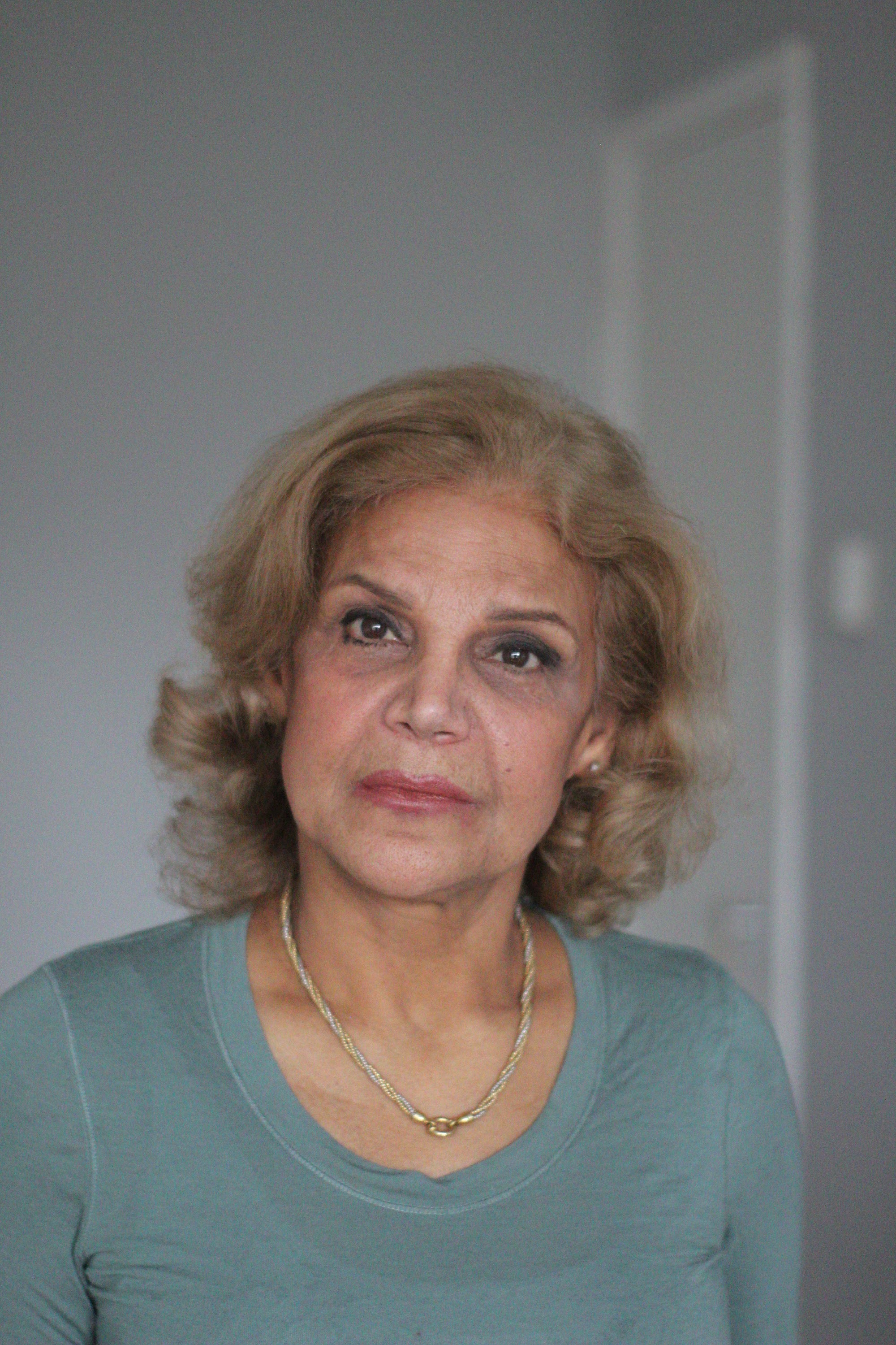 Indoor Portrait of Older Woman in Teal Long-Sleeve Top