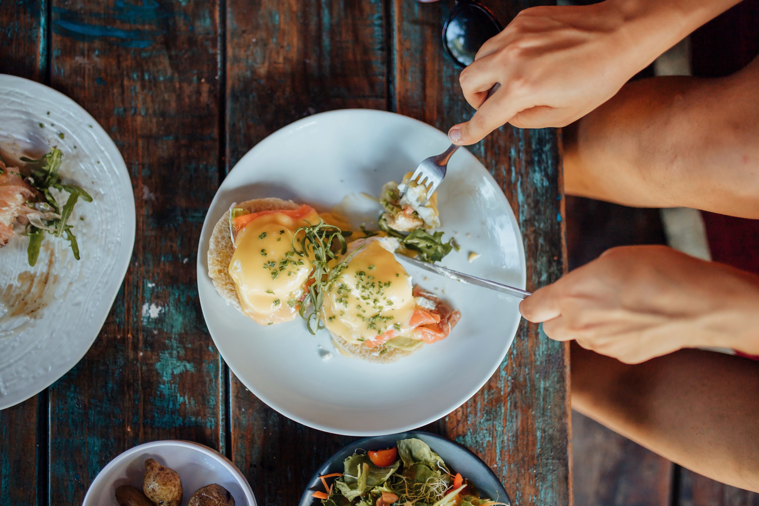 Eating Eggs Benedict at a Rustic Wooden Table