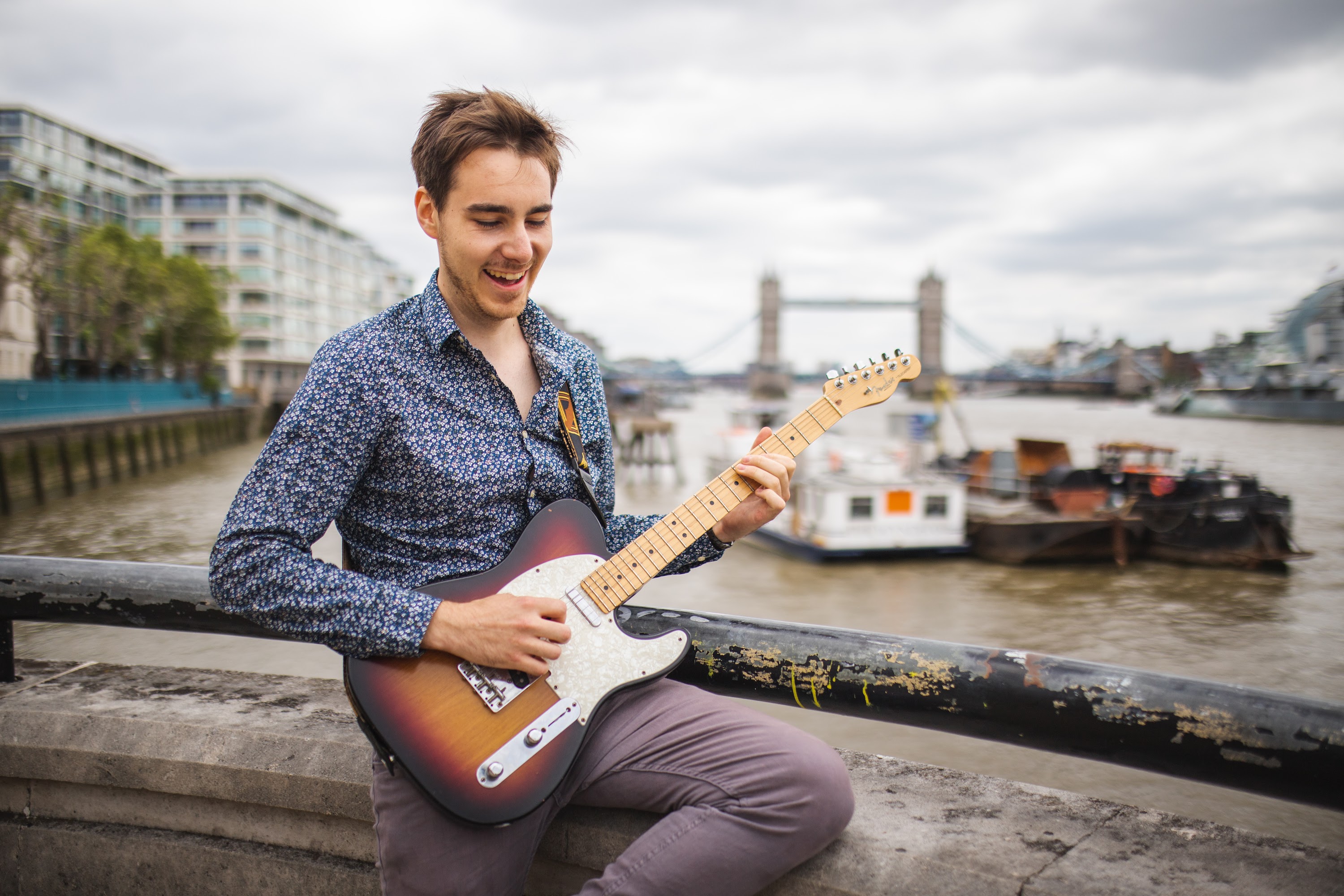 Young Man Playing Electric Guitar by the Thames