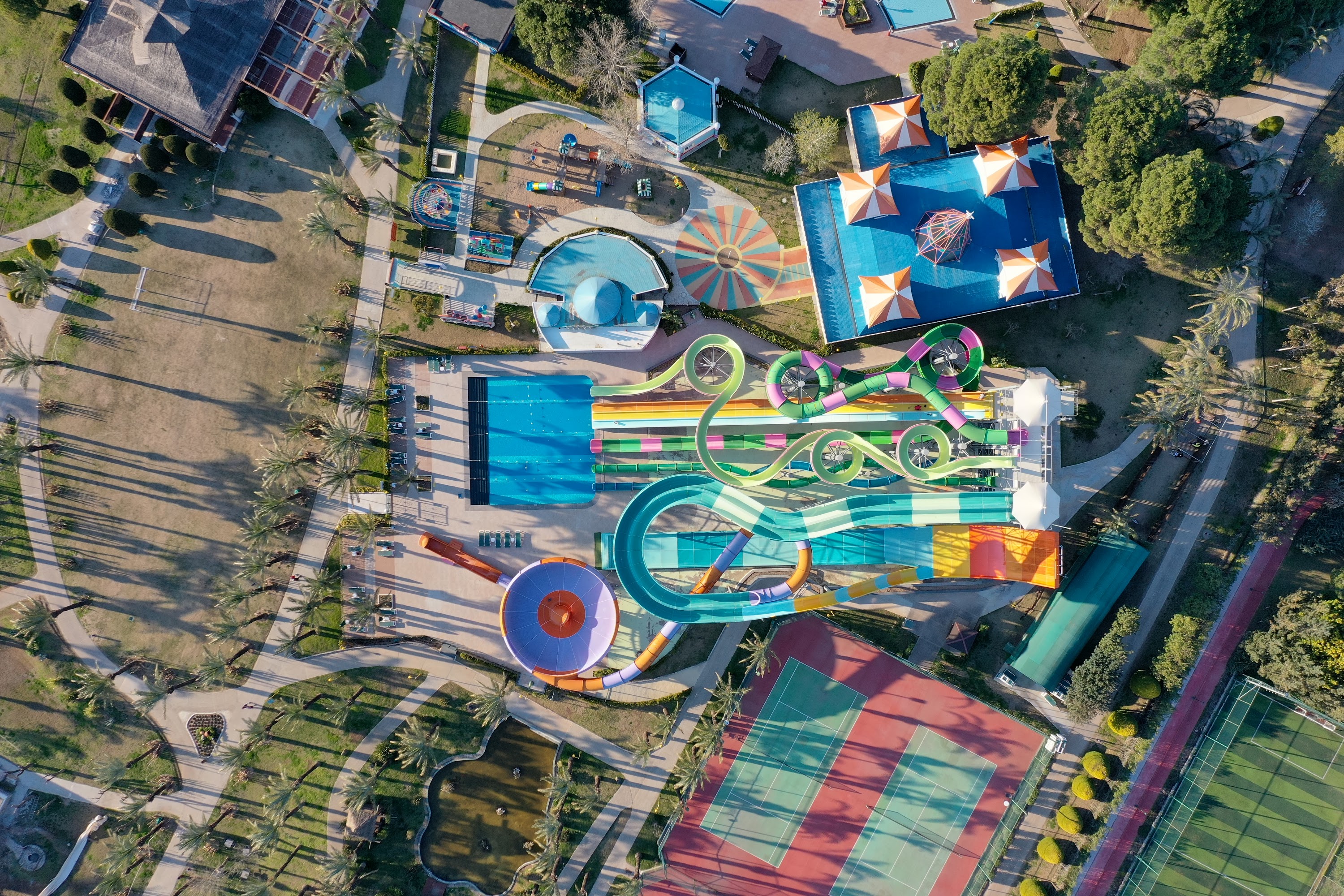 Aerial View of Water Park with Colorful Slides and Palm Trees