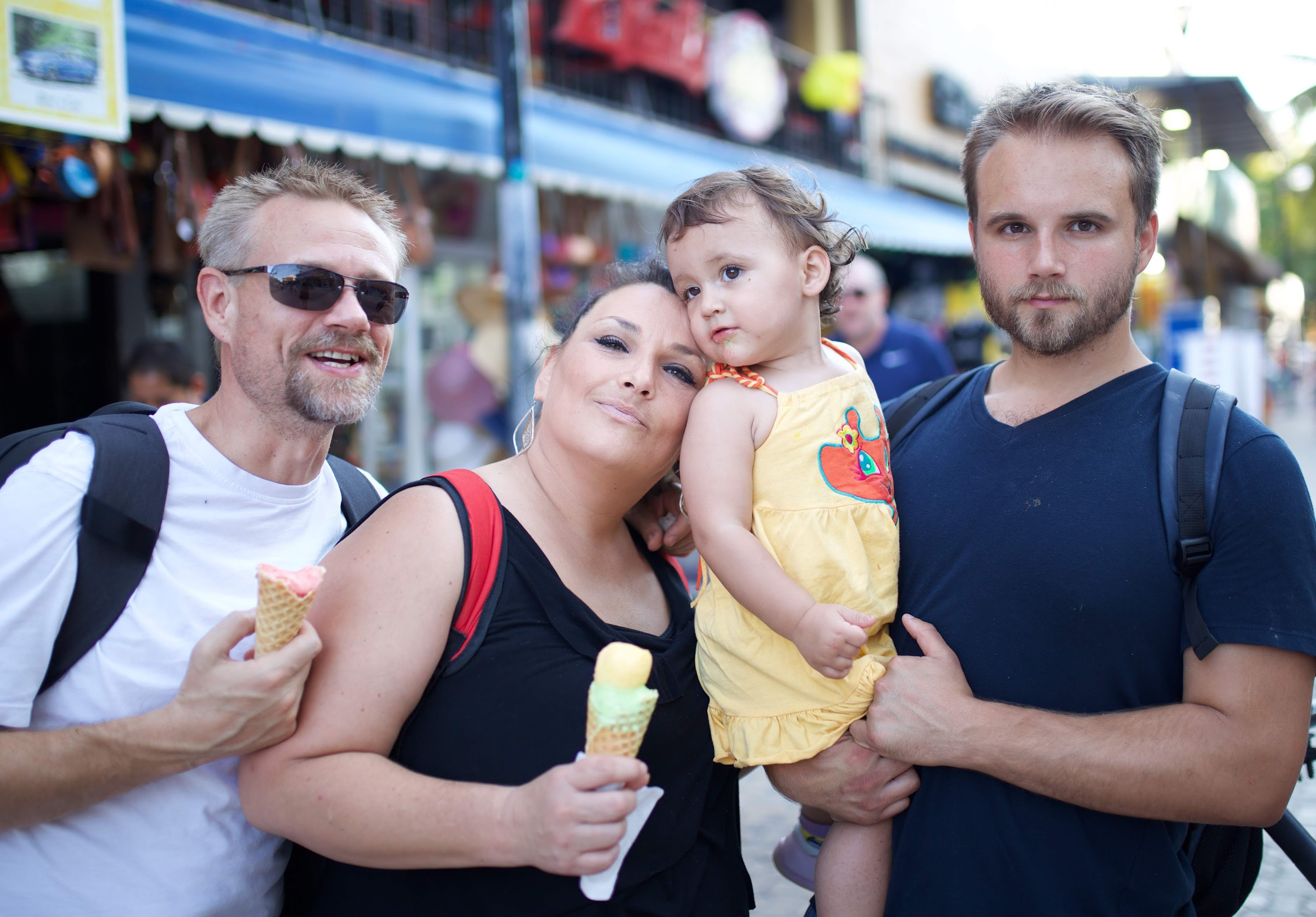 Family of Four Enjoying Ice Cream at Outdoor Market