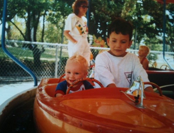 Two Boys on a Ride-Along Boat at an Amusement Park