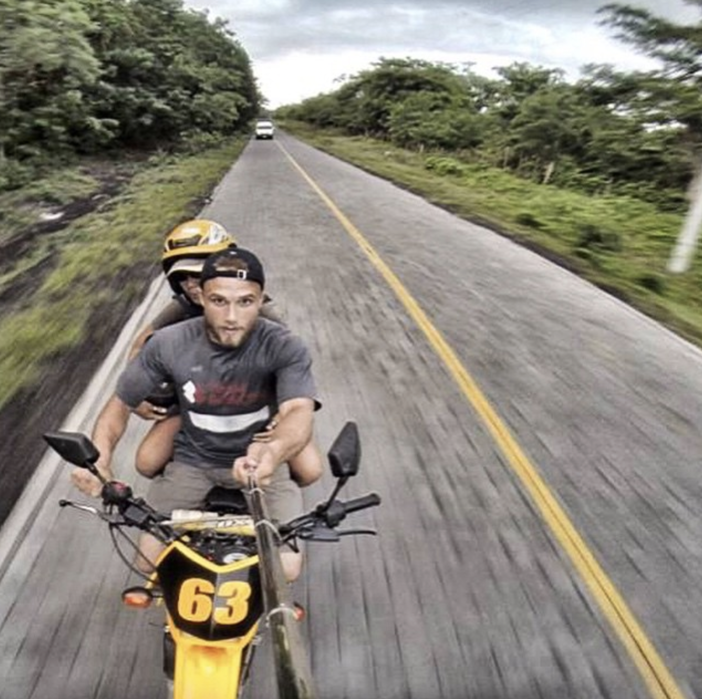 Two Men Riding a Motorcycle on a Rural Road