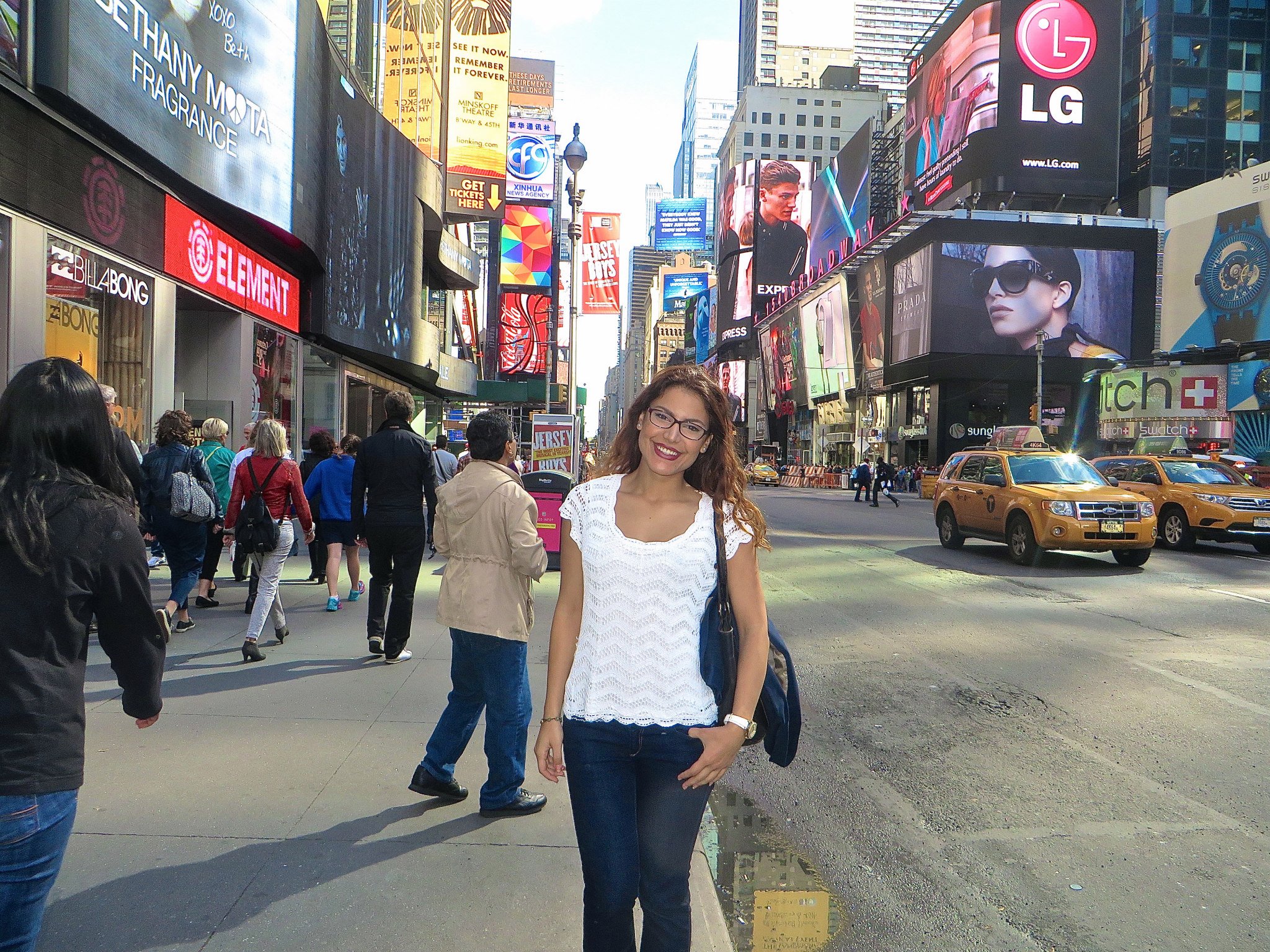 Woman smiling on a busy city street in Times Square