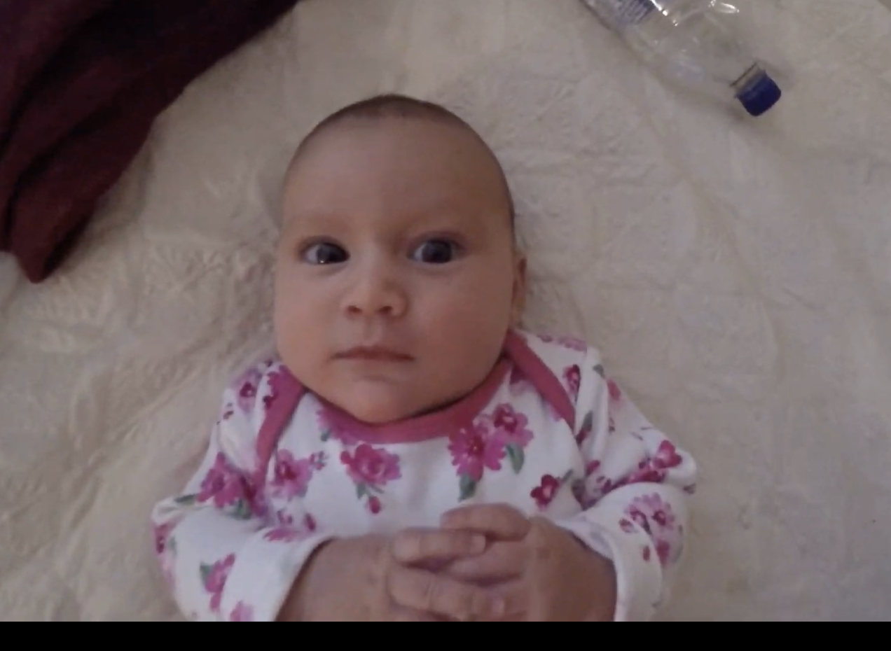 Baby in Floral Onesie Lying on Bed
