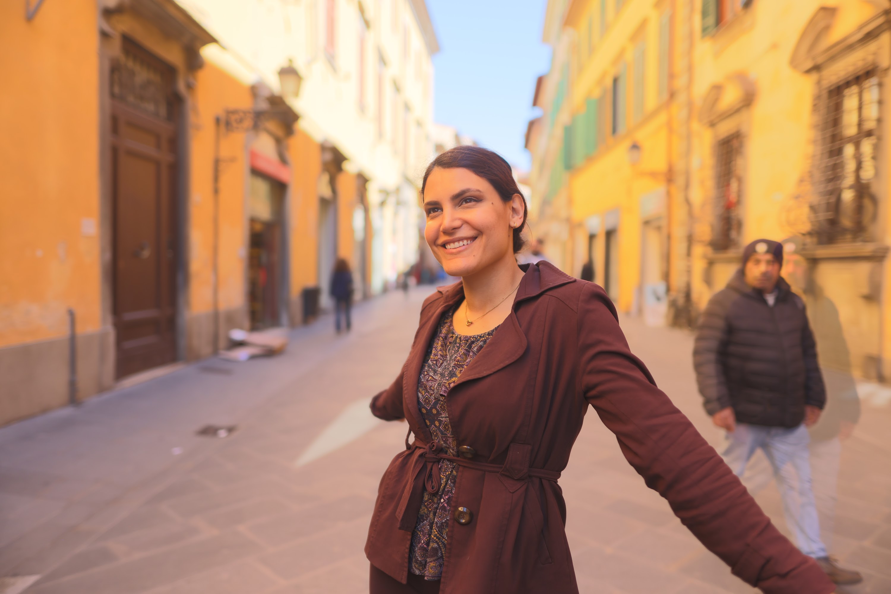 Smiling Woman Walking Down a Sunlit Italian Street