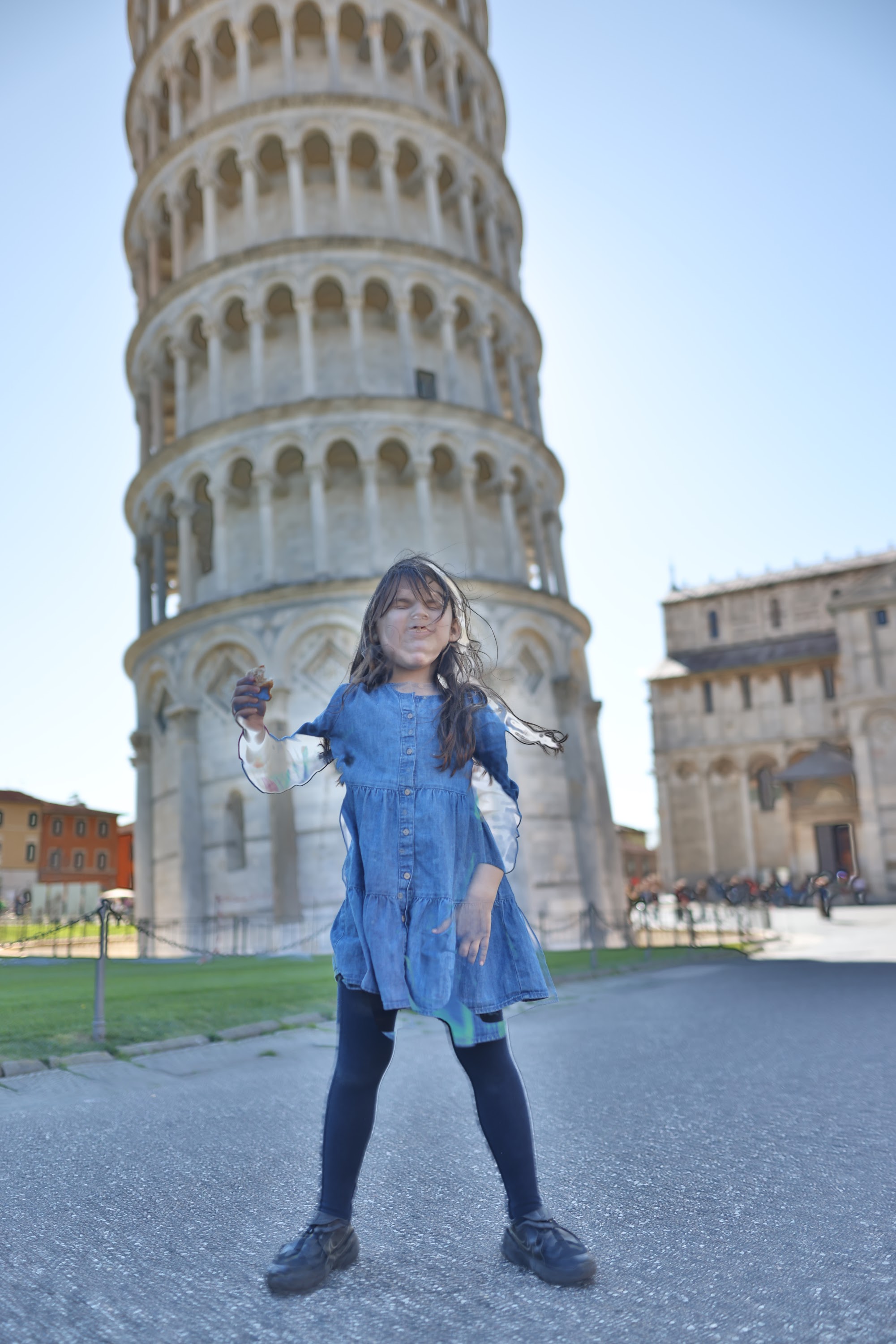 Girl Posing Playfully in Front of the Leaning Tower of Pisa