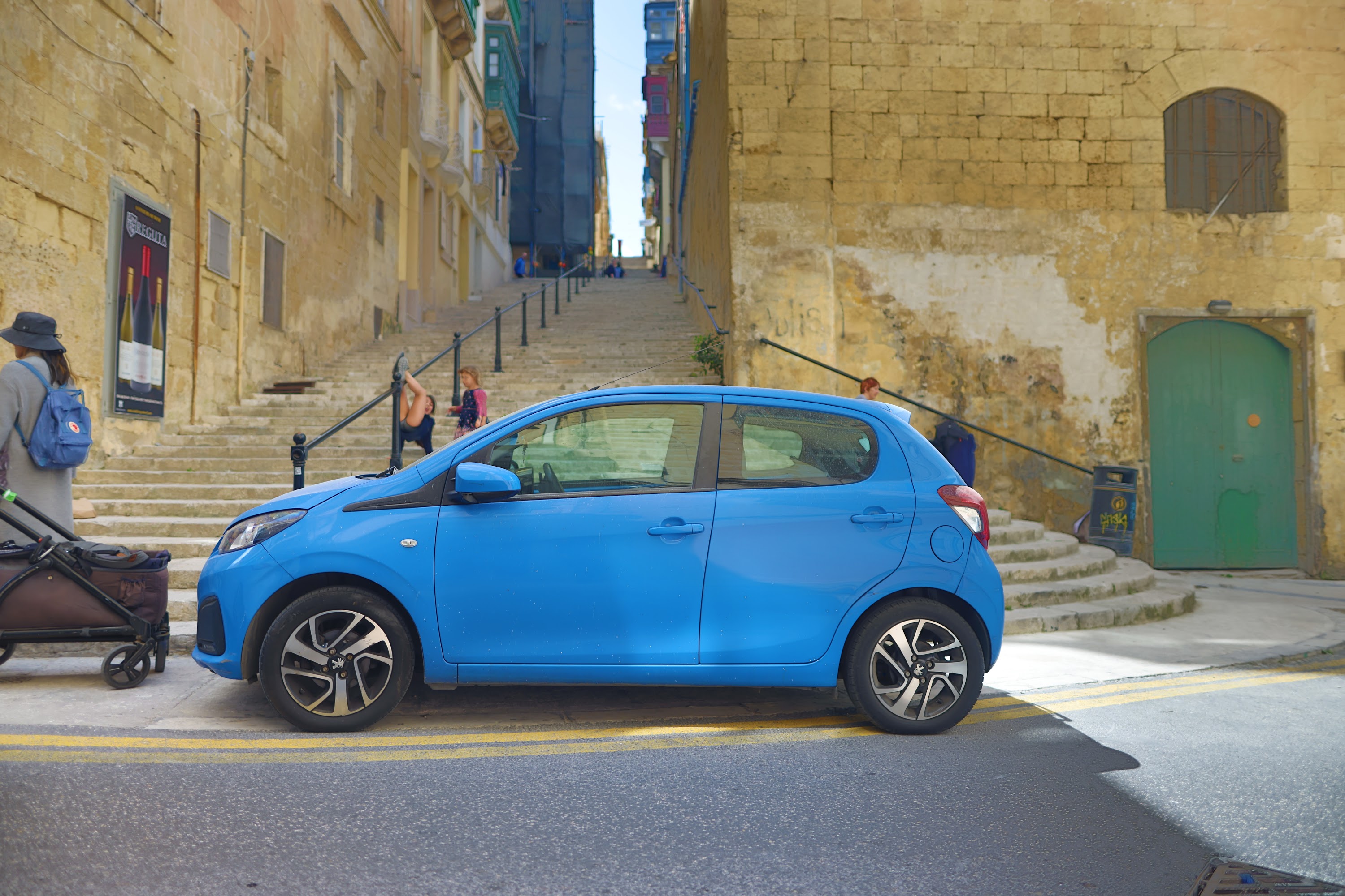 Blue Peugeot 108 Parked on a Historic Street
