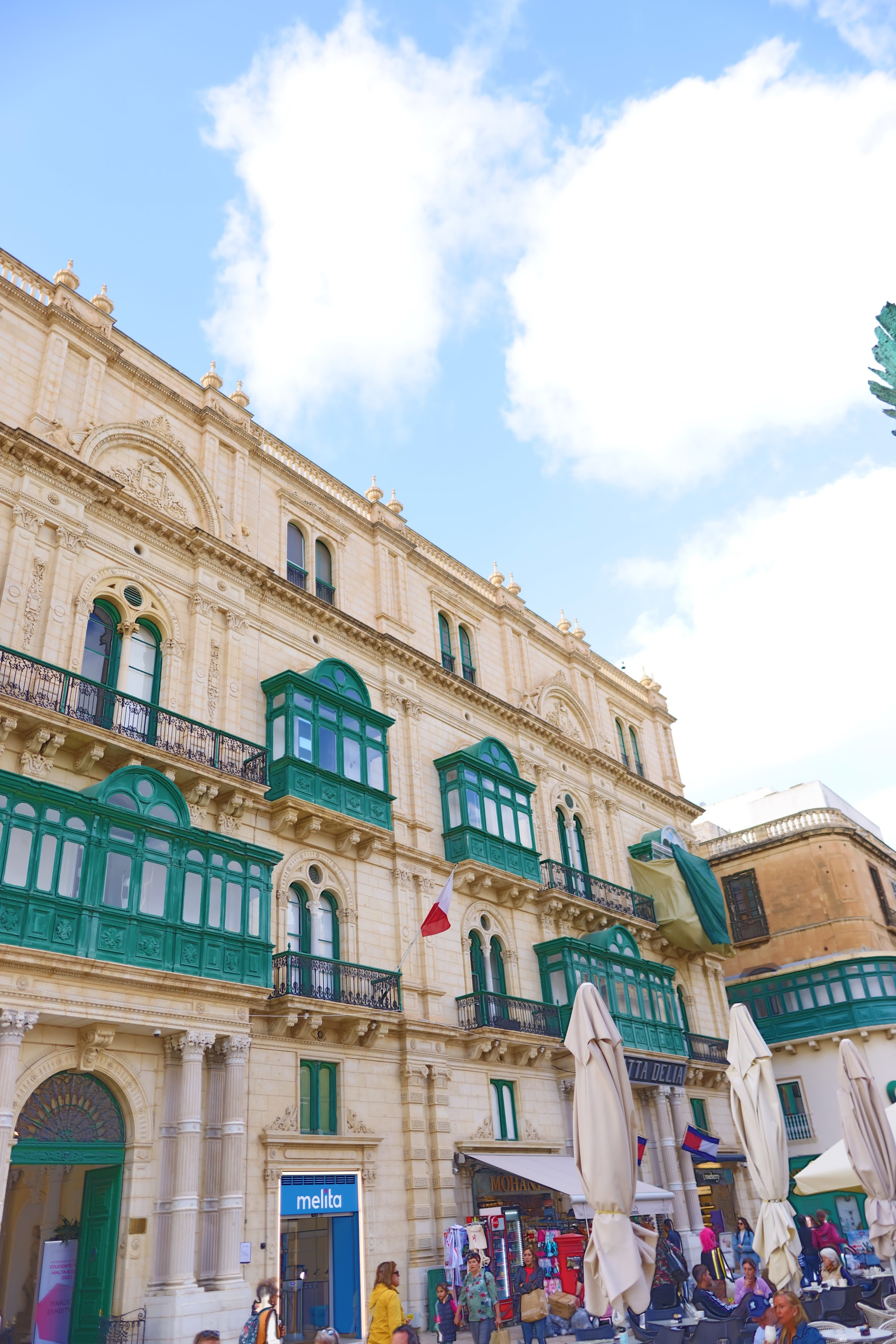 Historic Building with Green Balconies in a Sunlit Square
