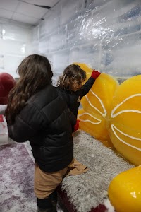 Children Interacting with Large Yellow Ice Sculptures
