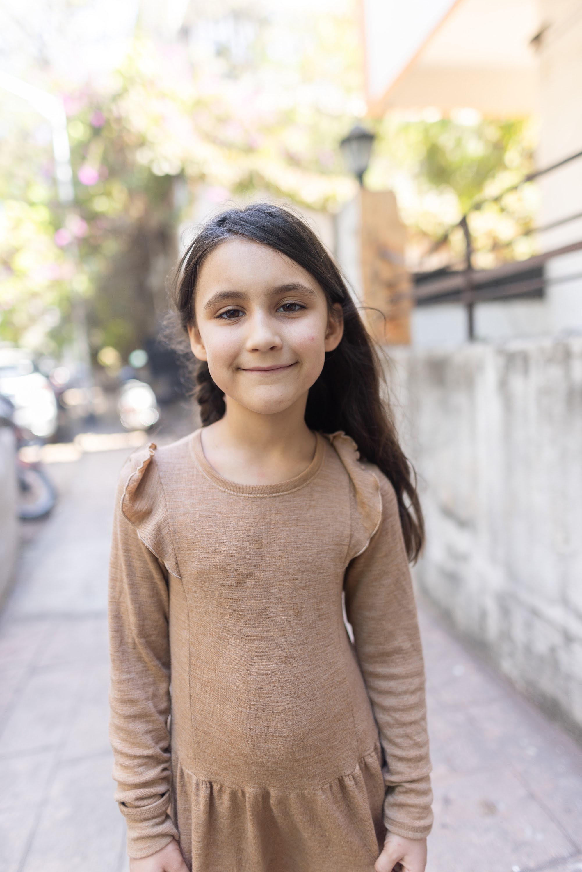 Girl Smiling in Brown Dress on Street