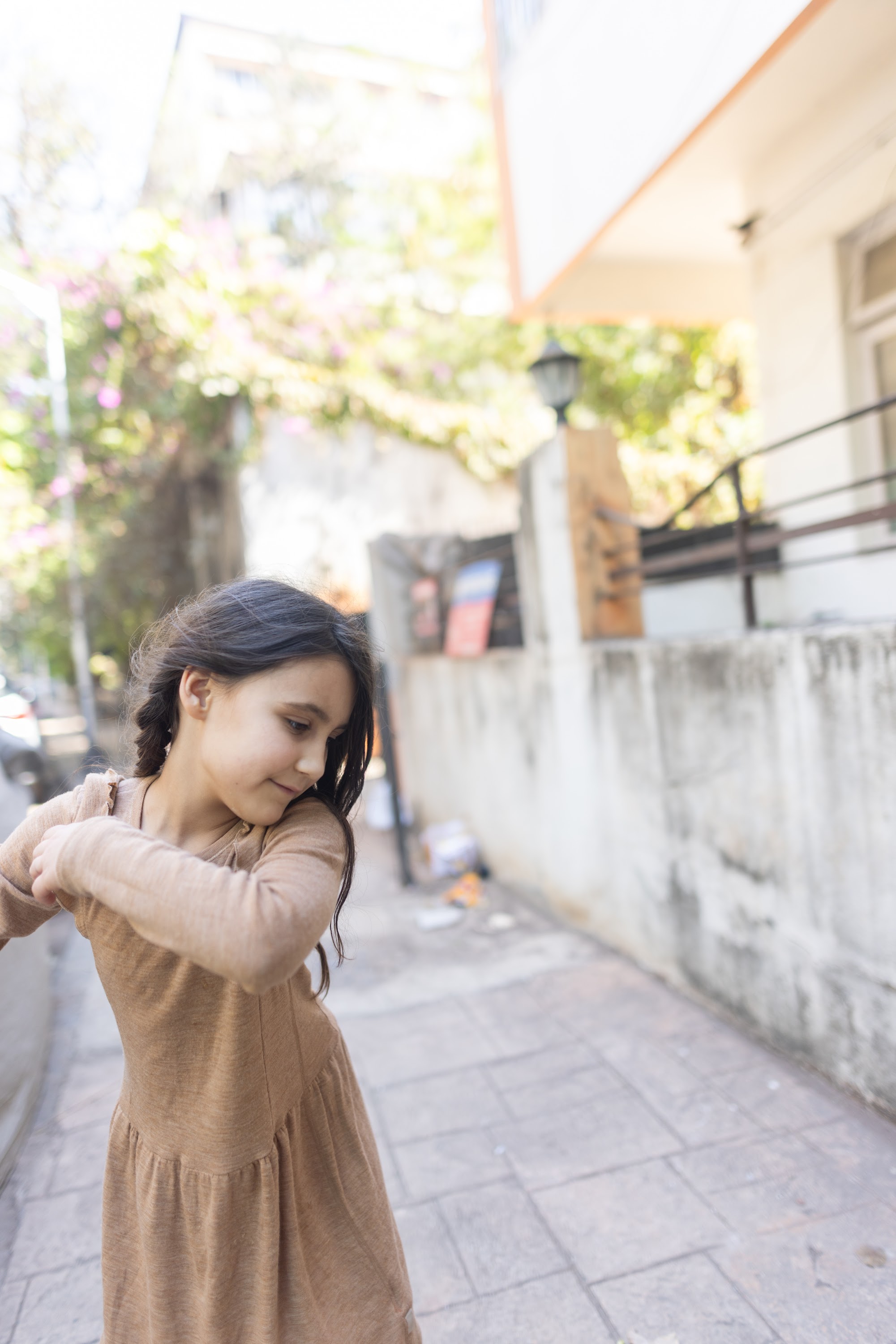 Girl in Brown Dress on a Sunlit Street