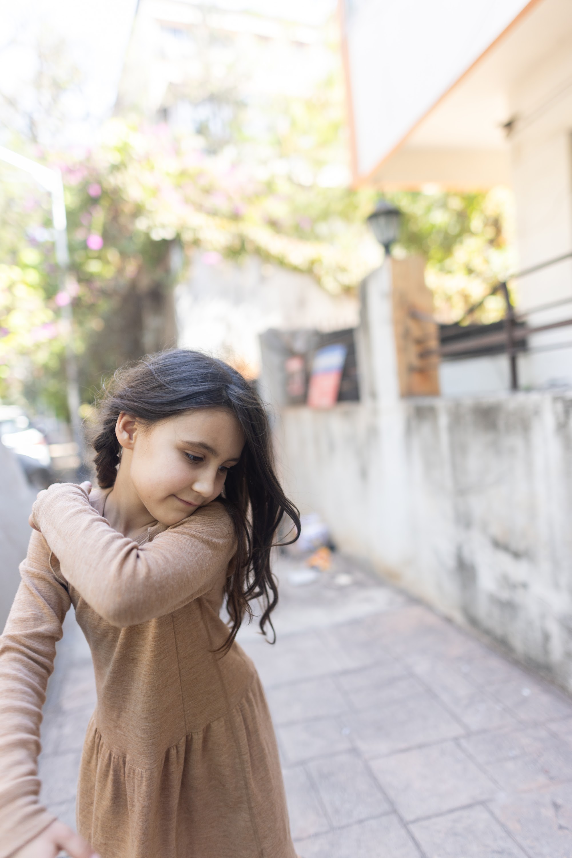 Girl in Brown Dress on Sunlit Street