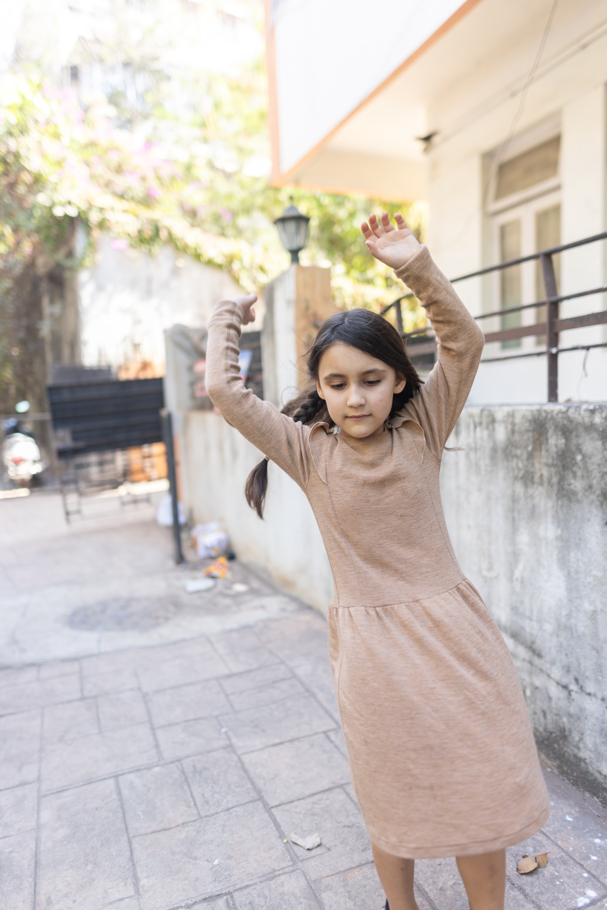 Girl Dancing Outdoors in Brown Dress