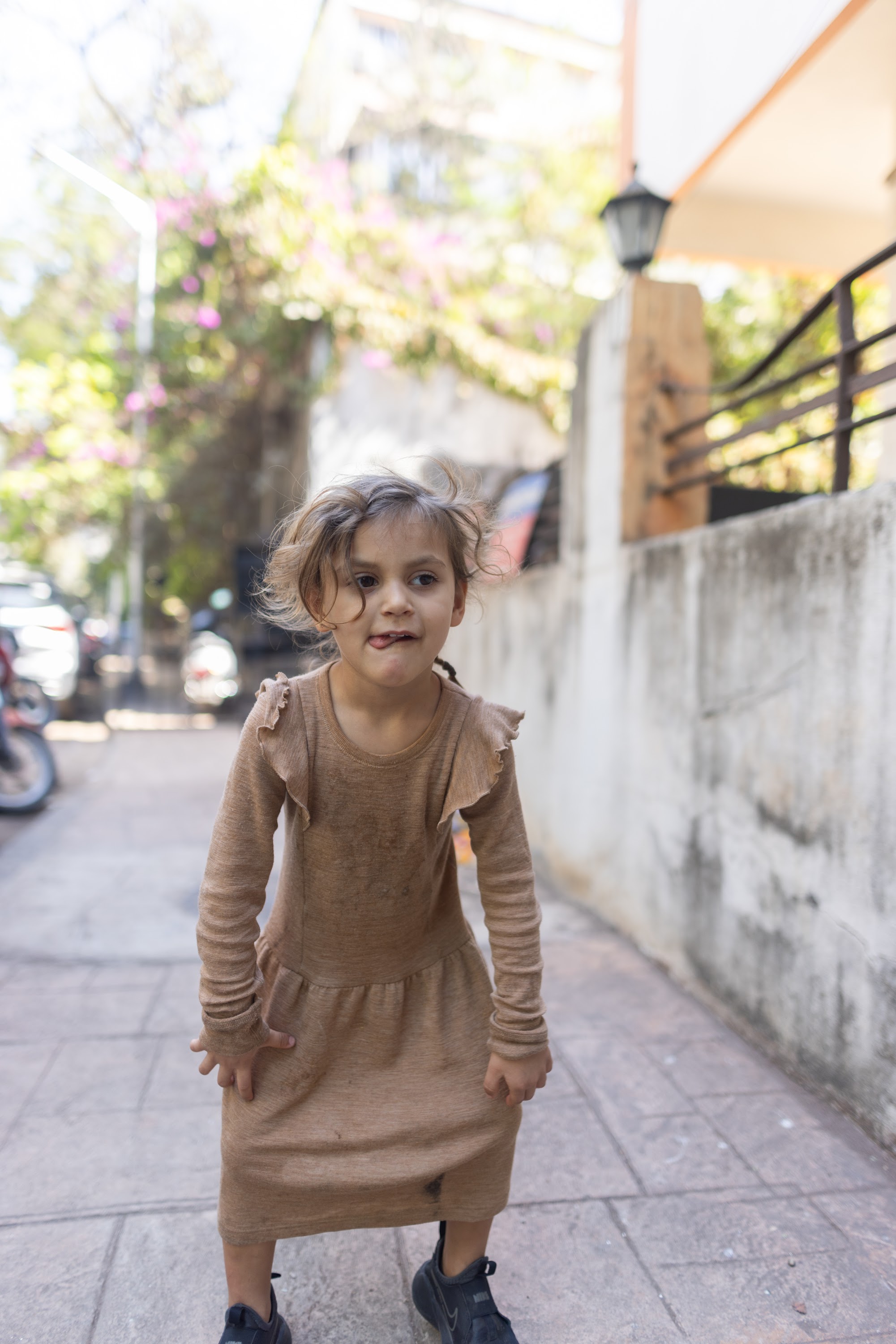Playful Girl in Brown Dress on Street