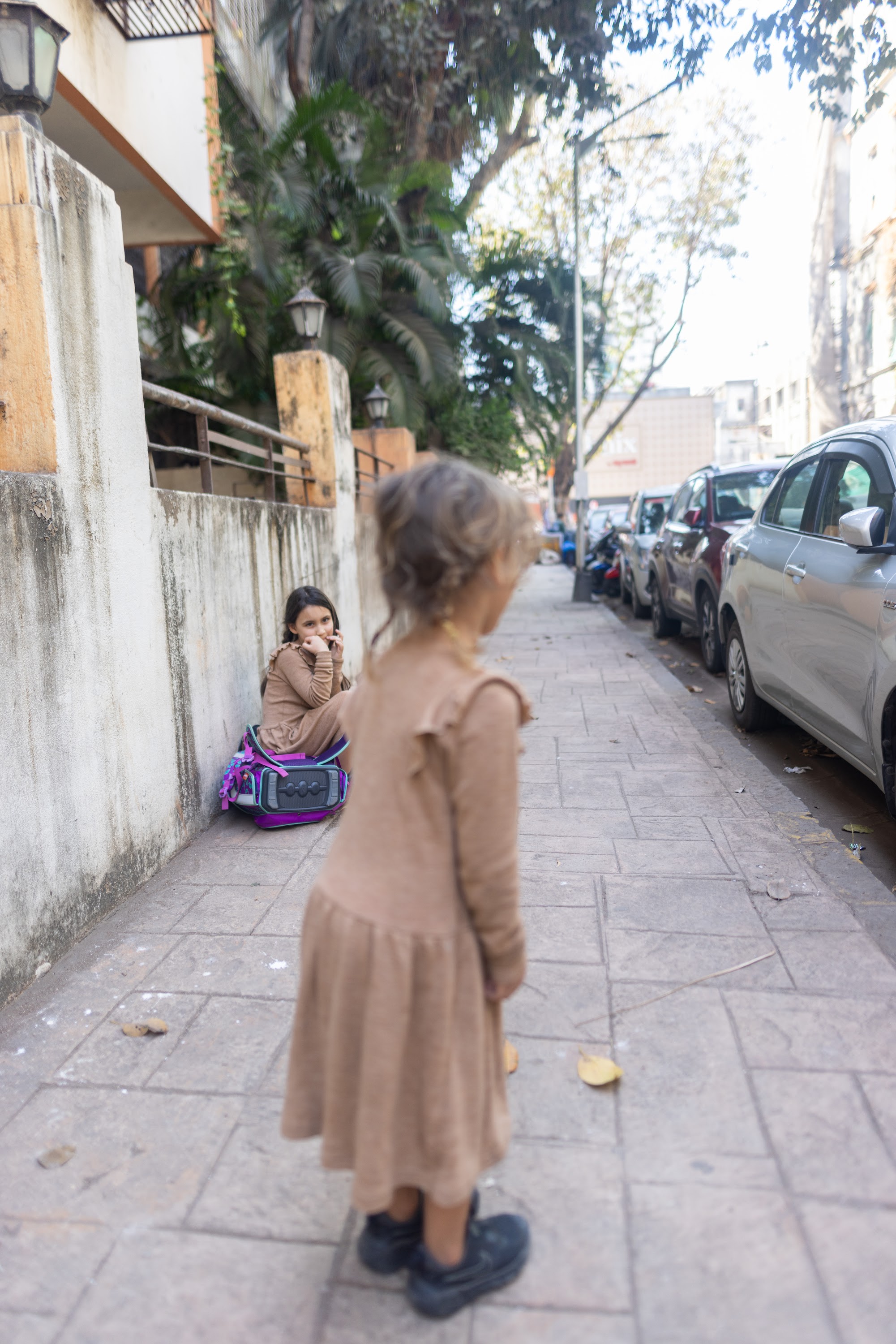 Two Young Girls on Urban Sidewalk