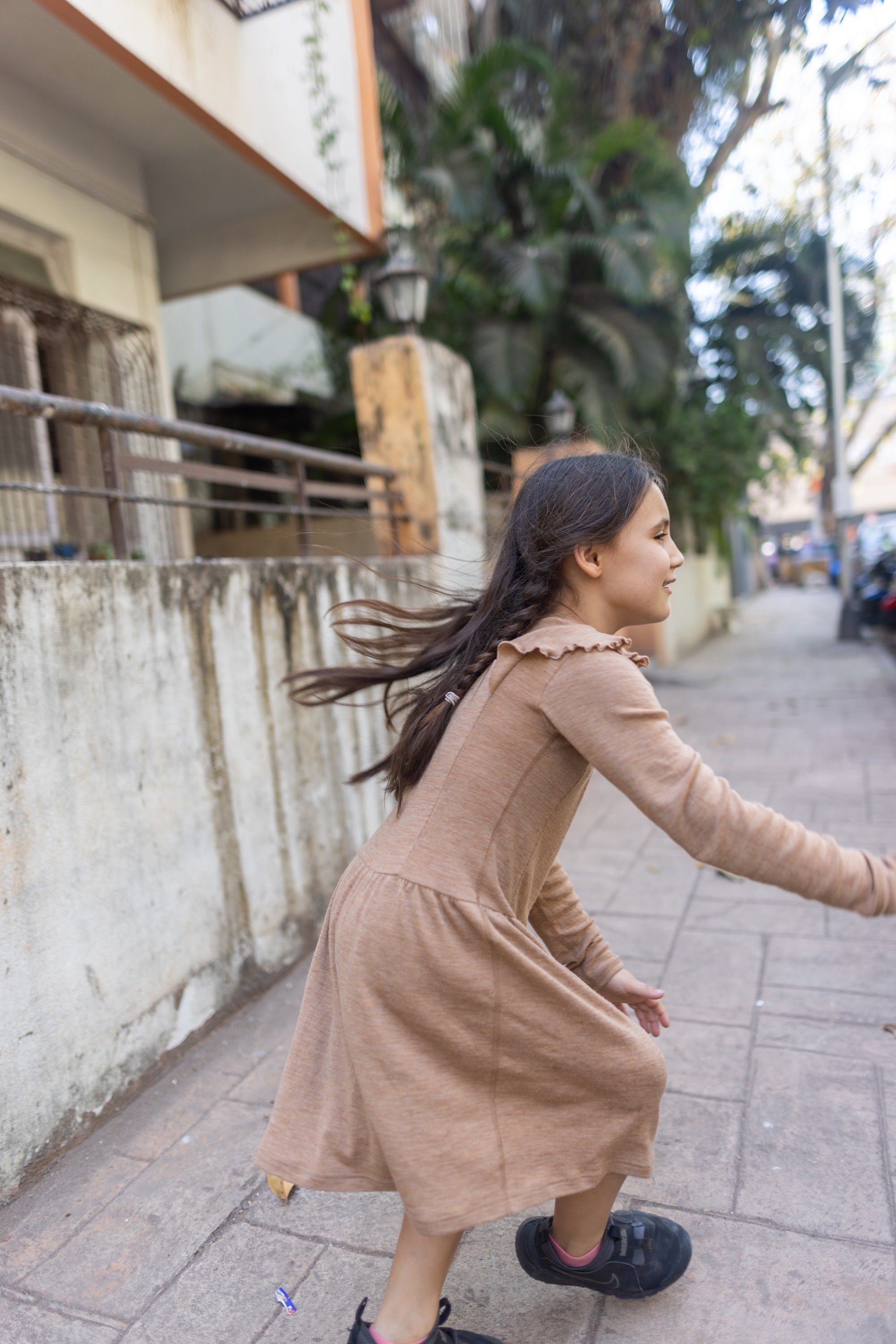 Young Girl Running on Sidewalk with Wind in Hair