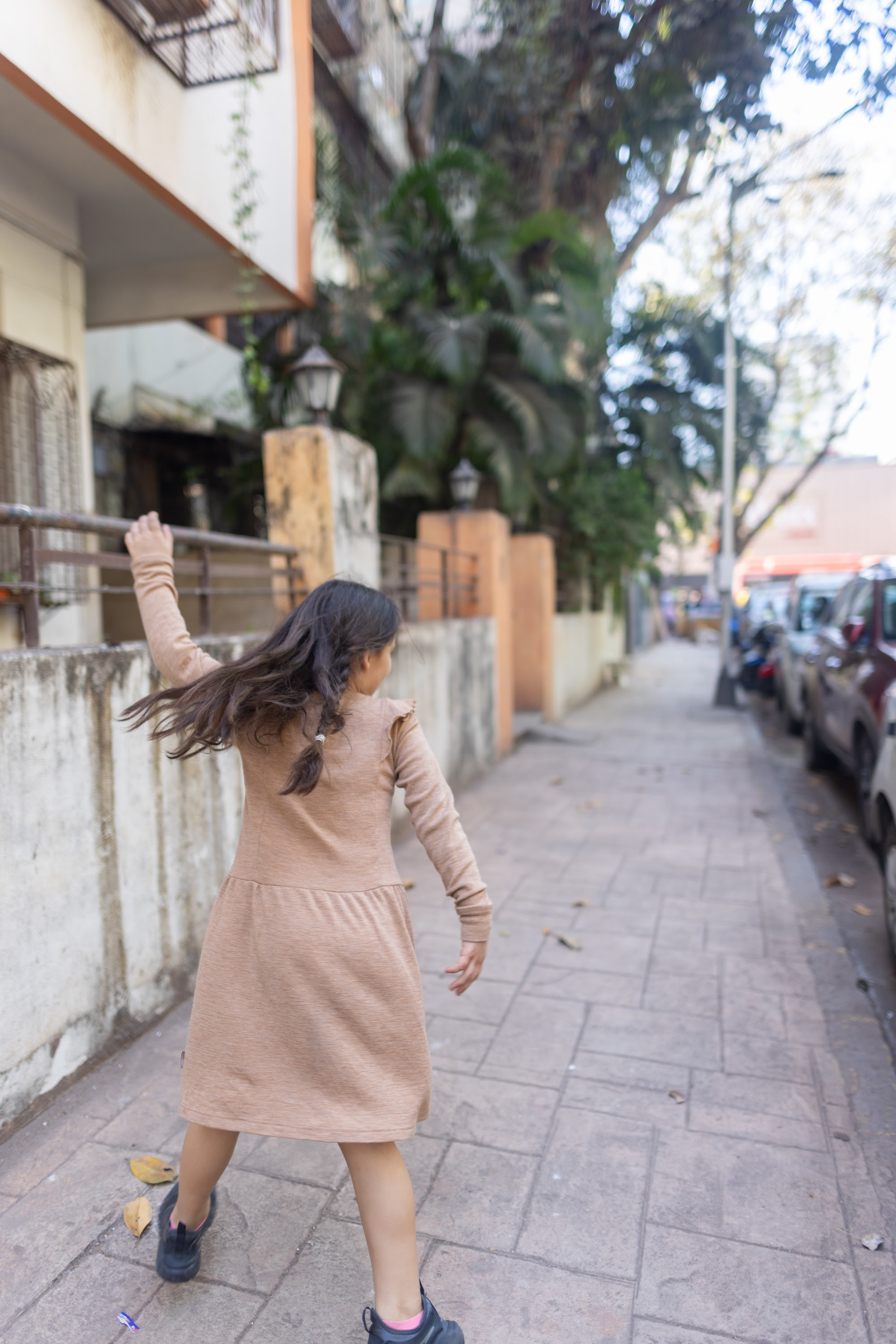 Girl Running on Sidewalk with Outstretched Arm