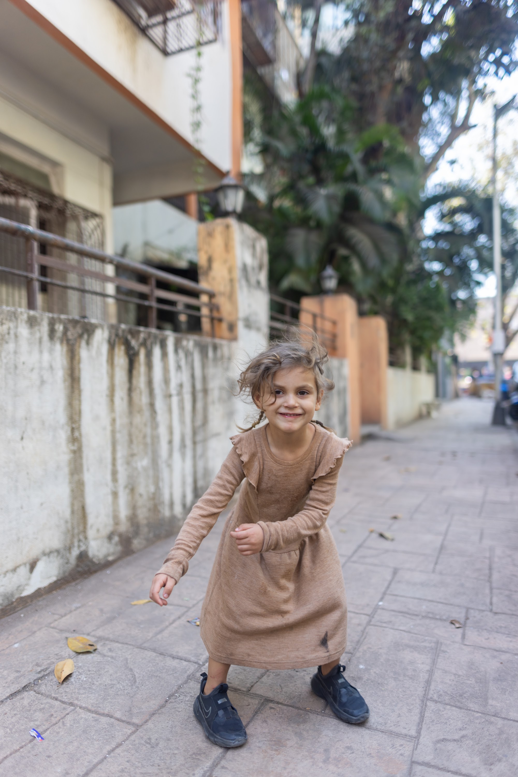 Joyful Girl Spinning on City Sidewalk