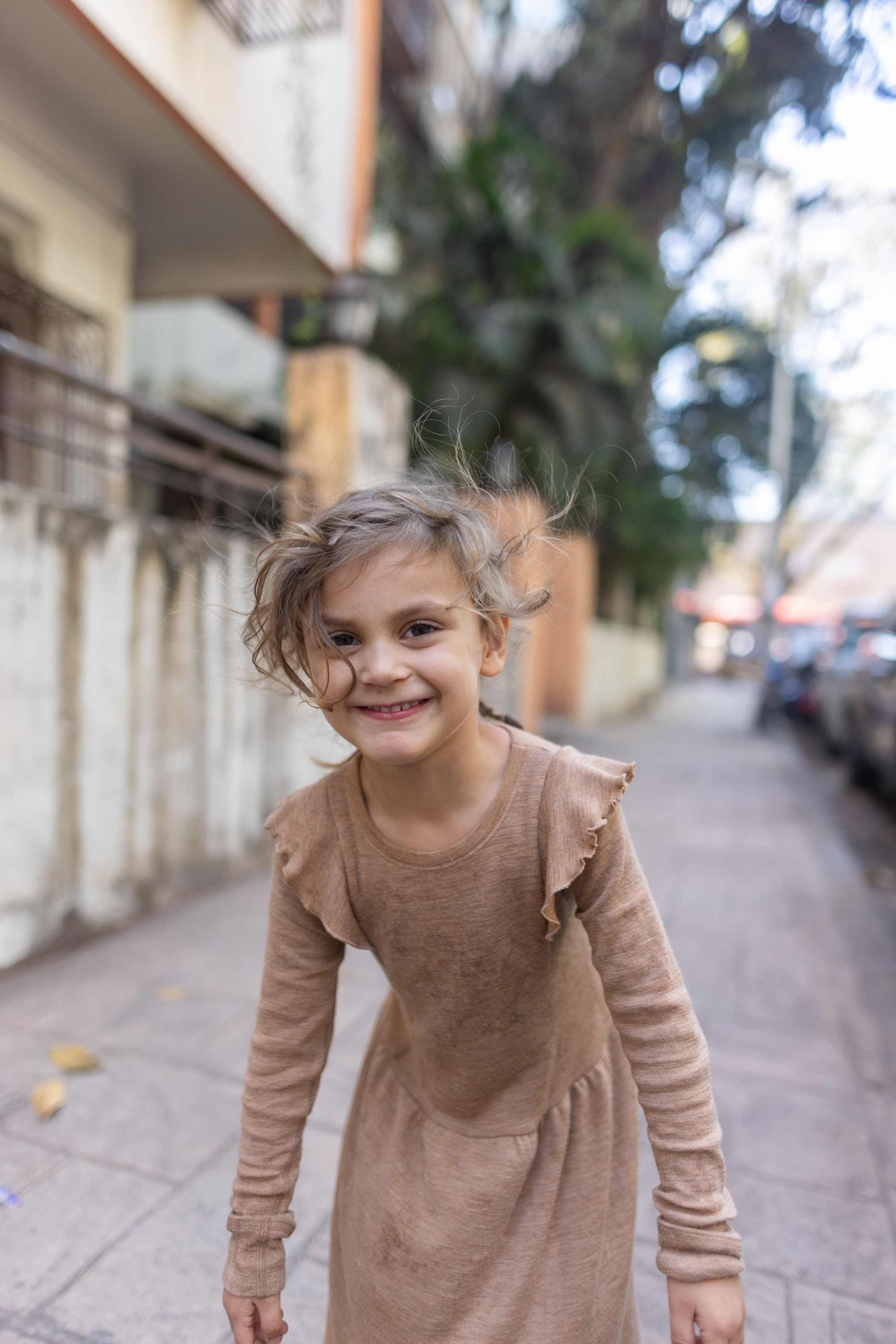 Joyful Girl Spinning on City Sidewalk