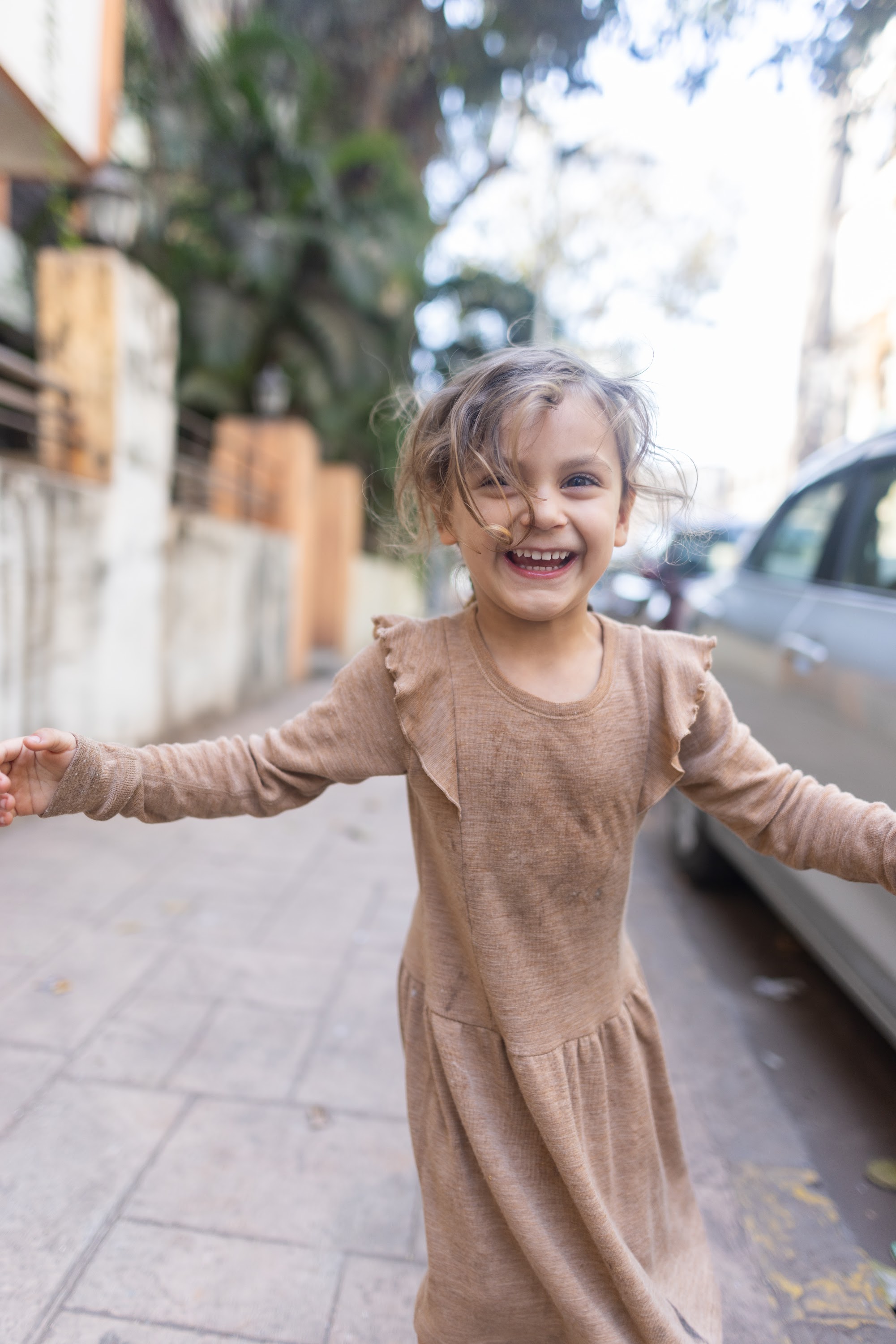 Joyful Girl Spinning on City Sidewalk