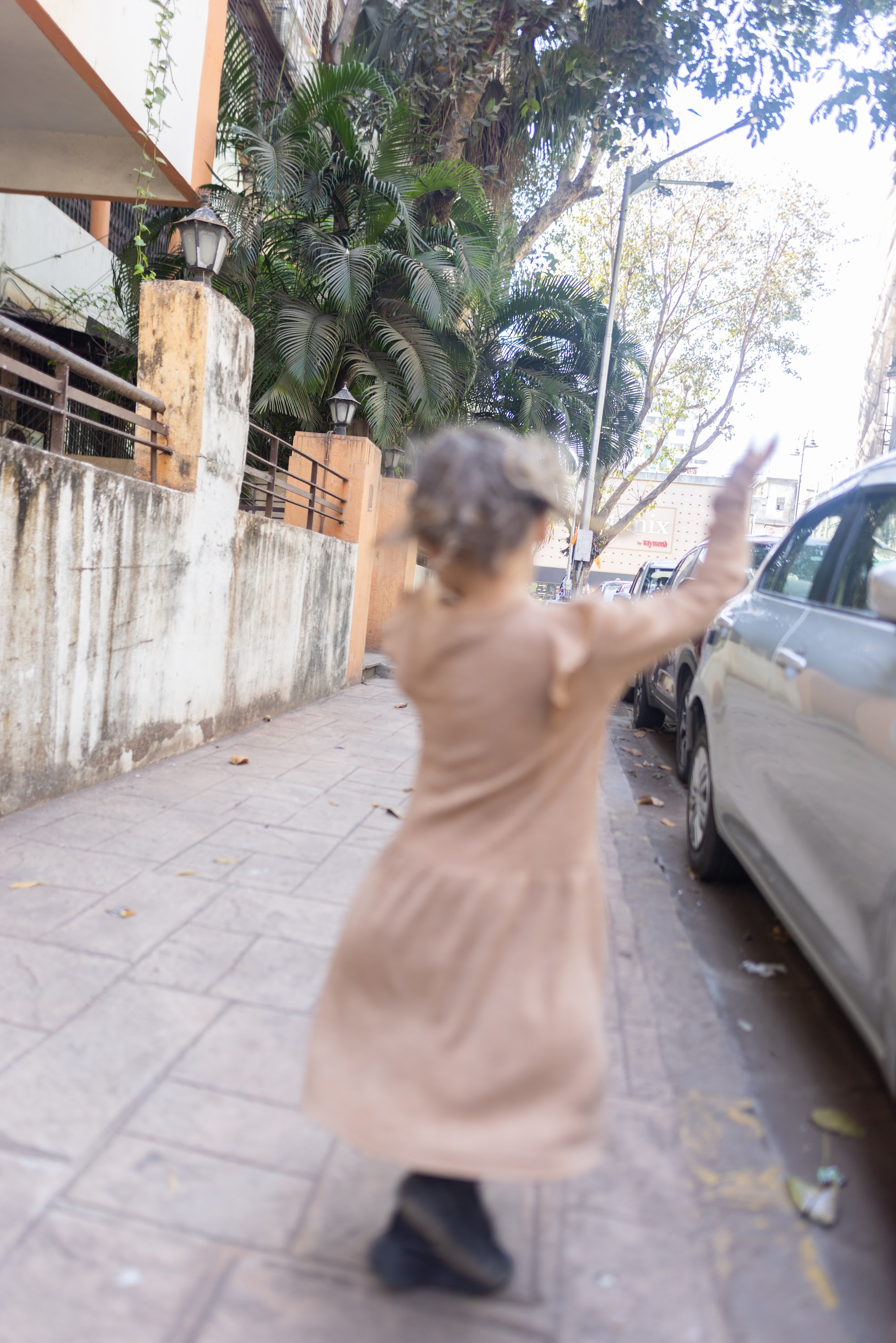 Child Spinning on Sidewalk