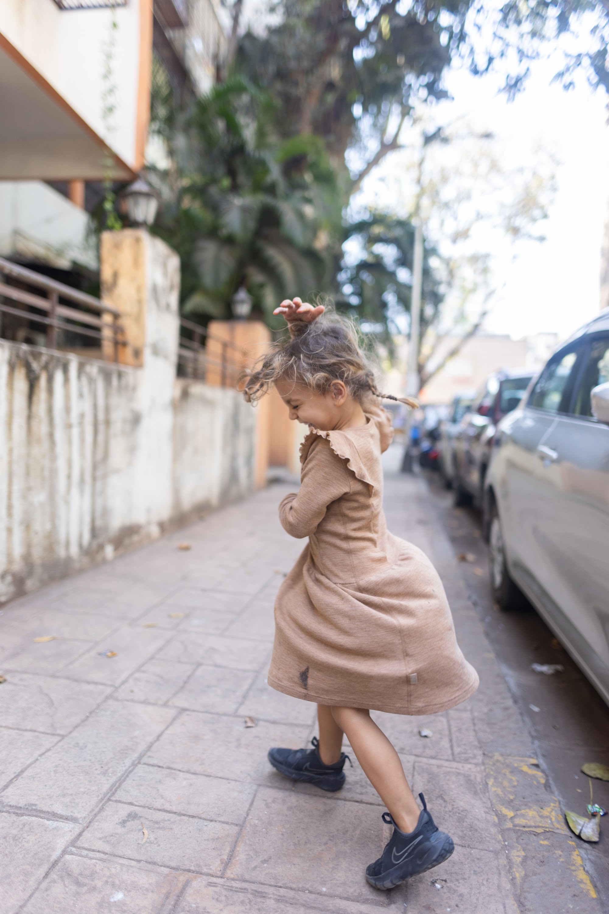 Joyful Girl Spinning on City Sidewalk