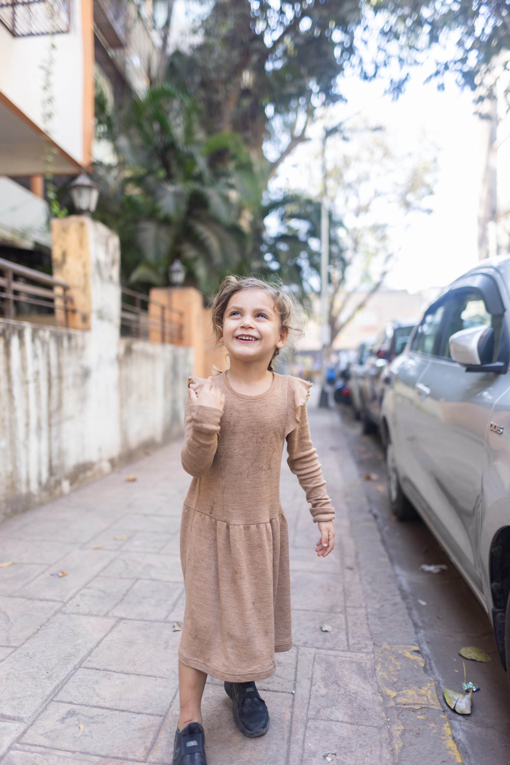 Girl Walking on Sidewalk with Smiling Expression