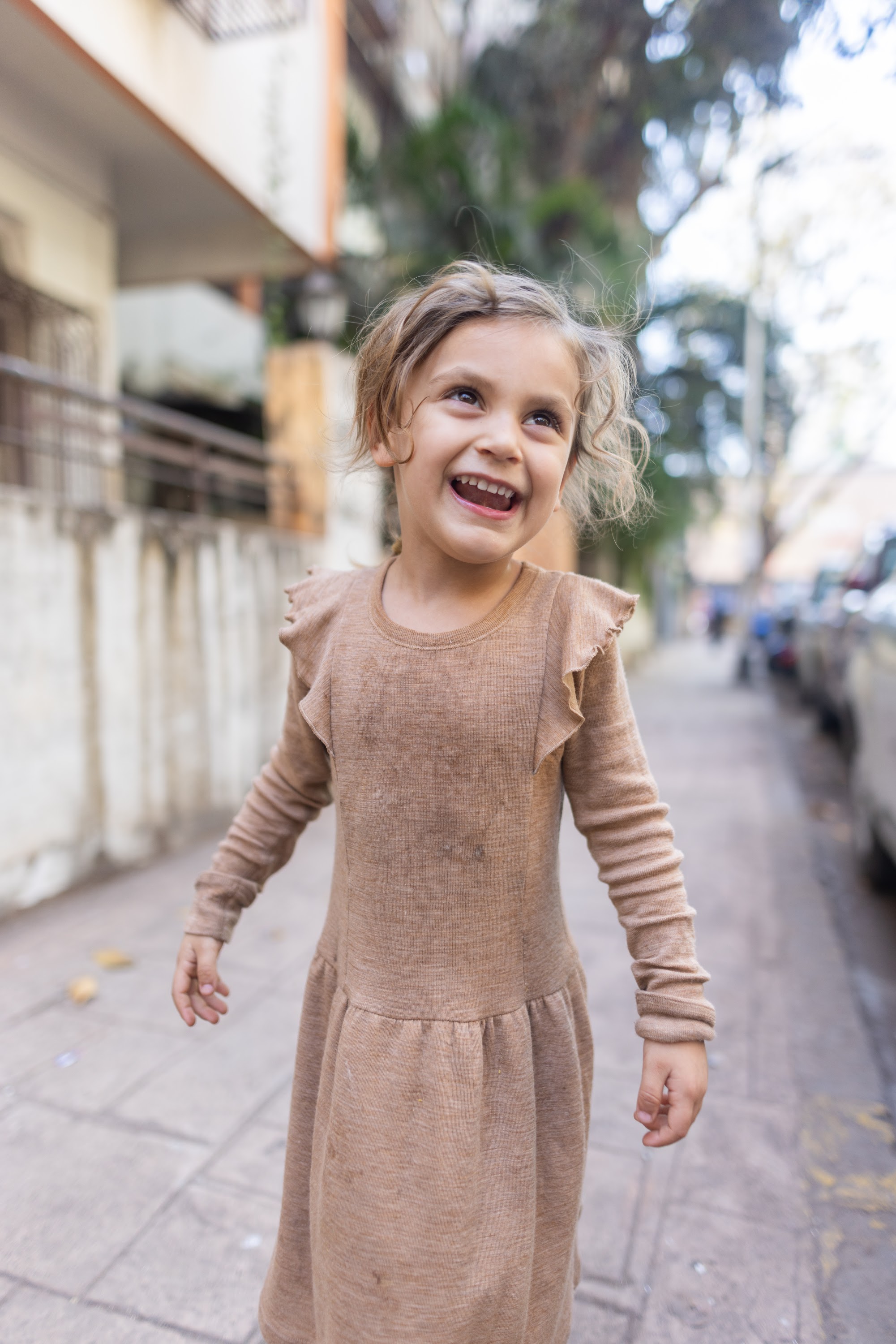 Joyful Girl Laughing on City Sidewalk